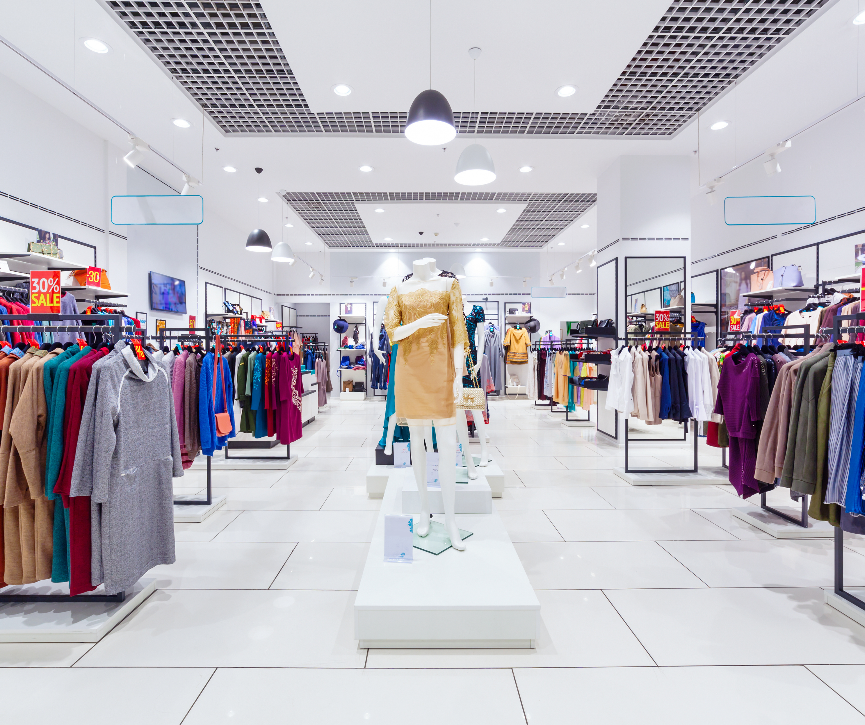  Interior view of a modern clothing store with mannequins and neatly organized racks of clothes.