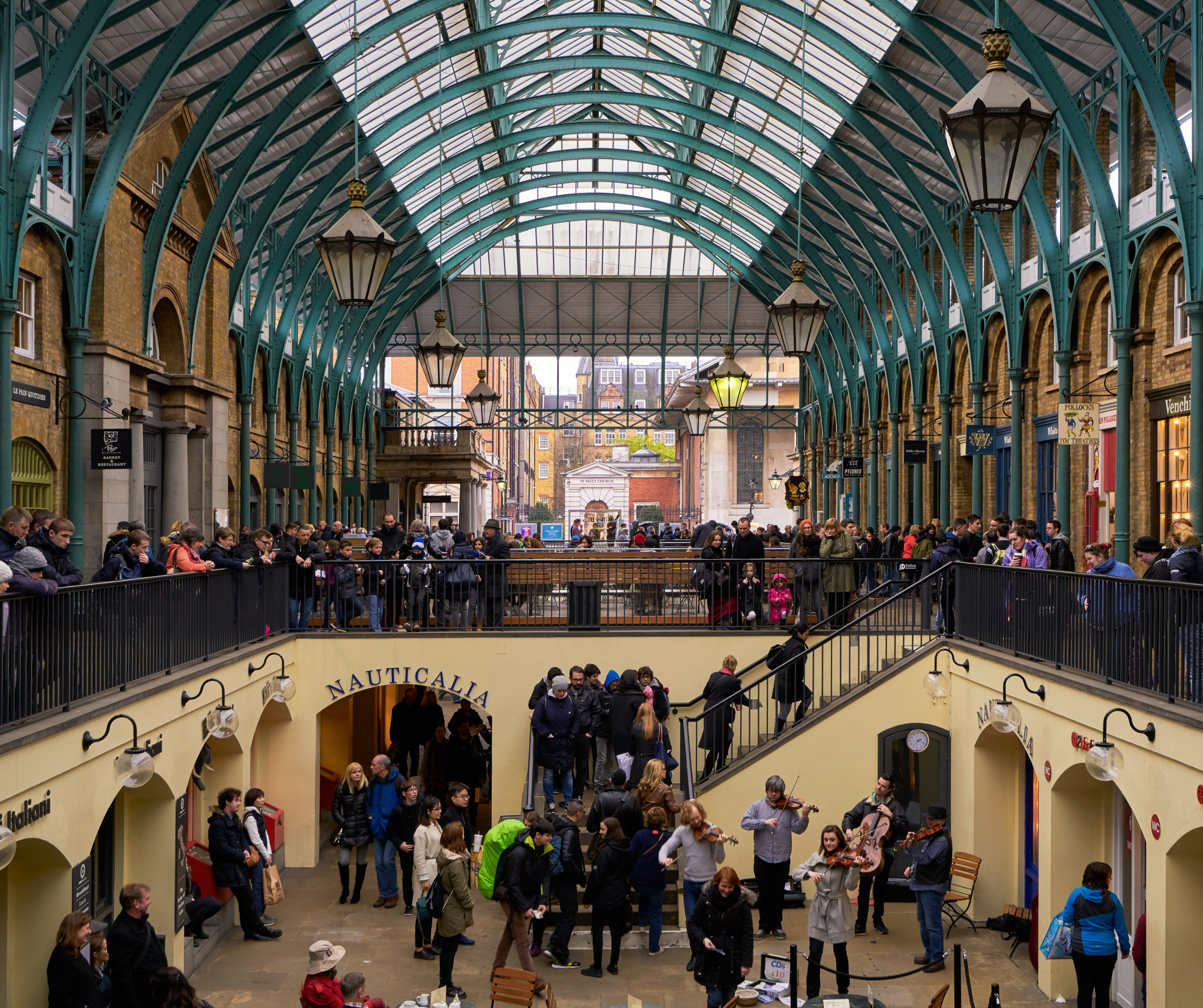 Interior of Covent Garden Market with a large crowd of people and street performers