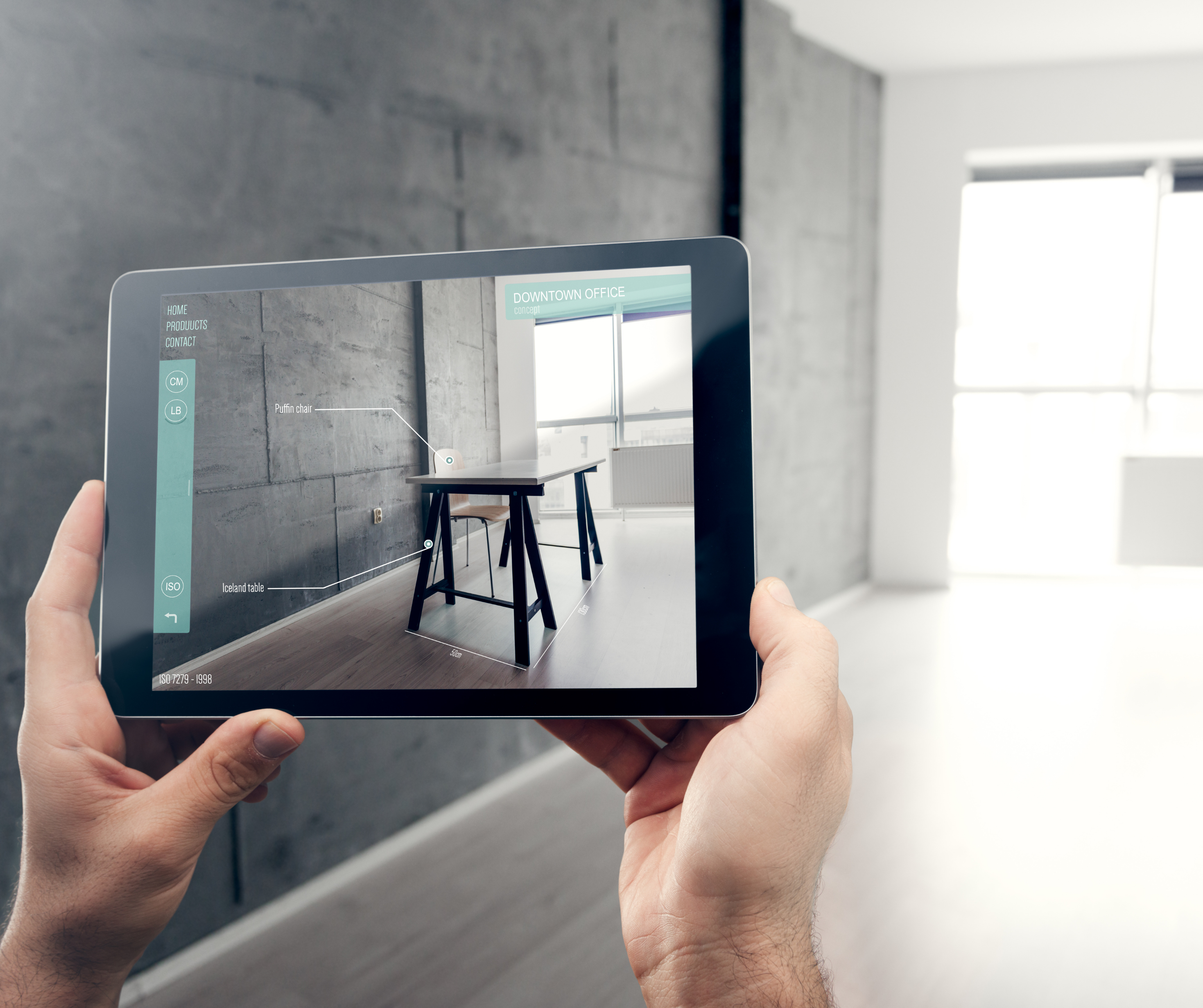 Person holding a tablet with an augmented reality application to visualize a furnished room.