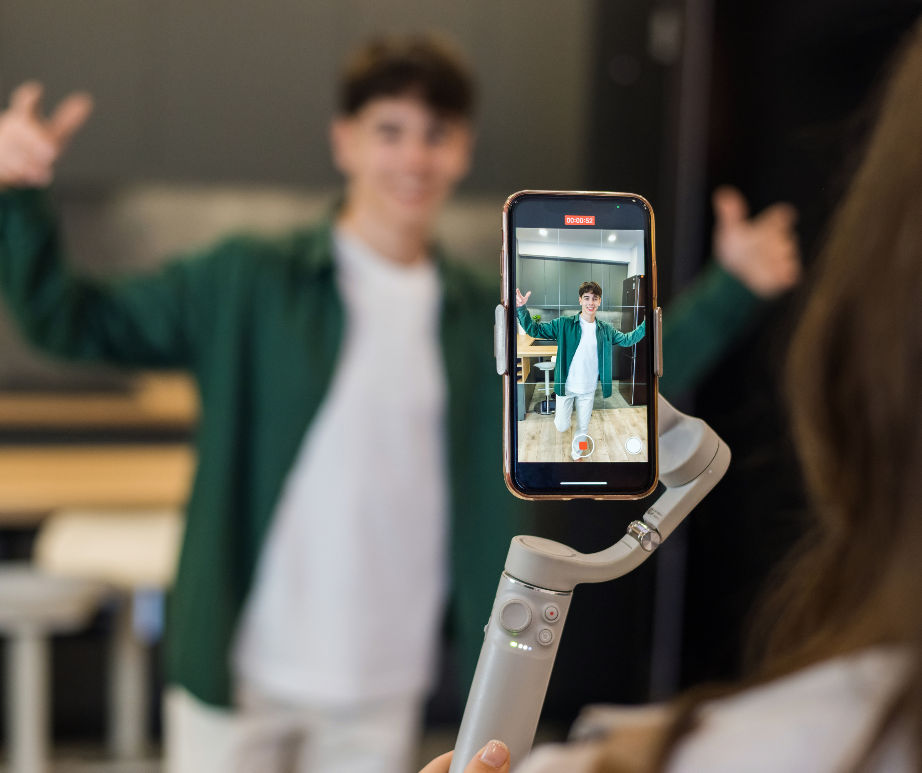 Influencer recording a video with a smartphone on a gimbal, capturing engaging content.