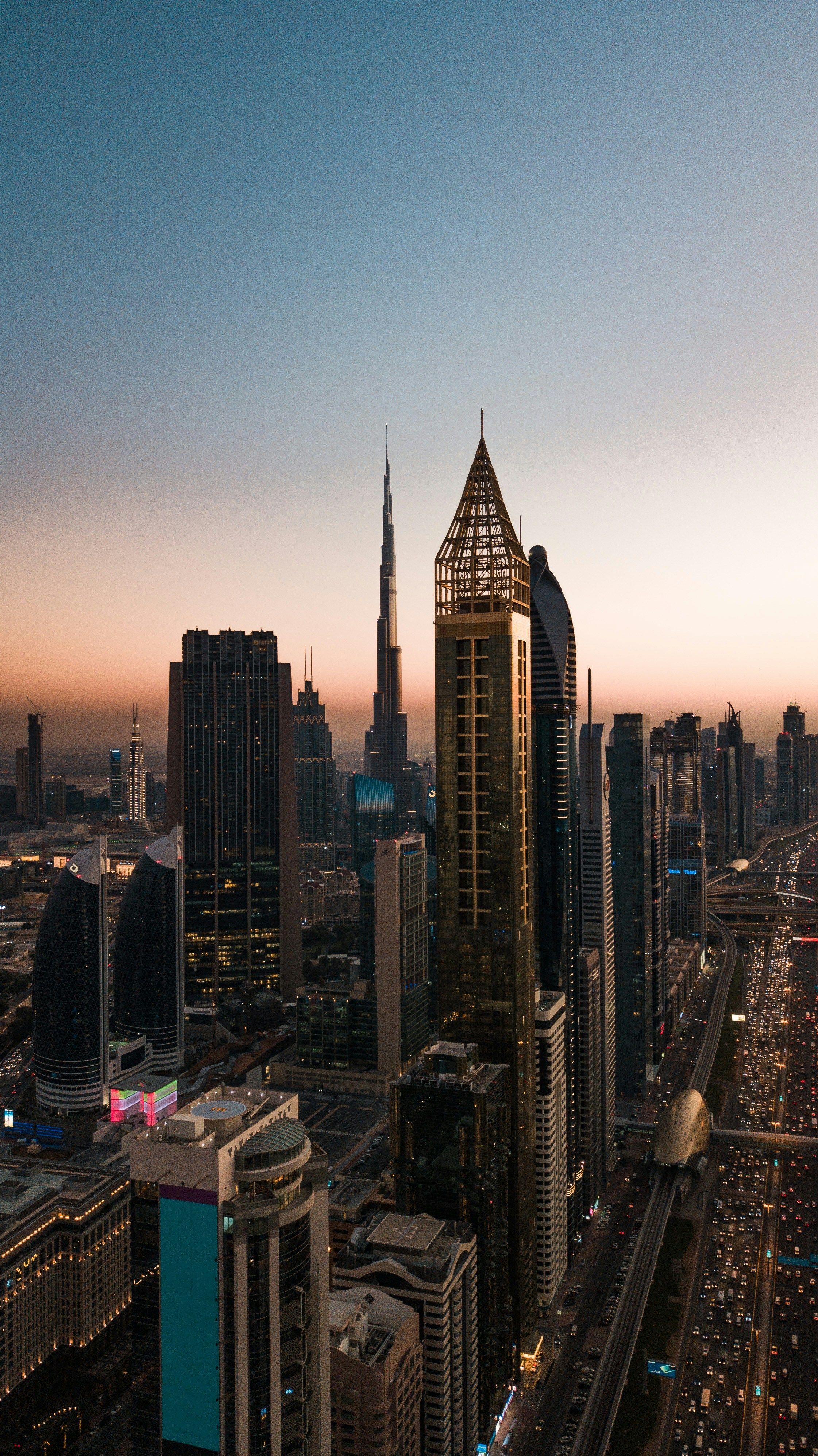 Aerial view of Dubai skyscrapers at sunset, with the Burj Khalifa towering over other buildings