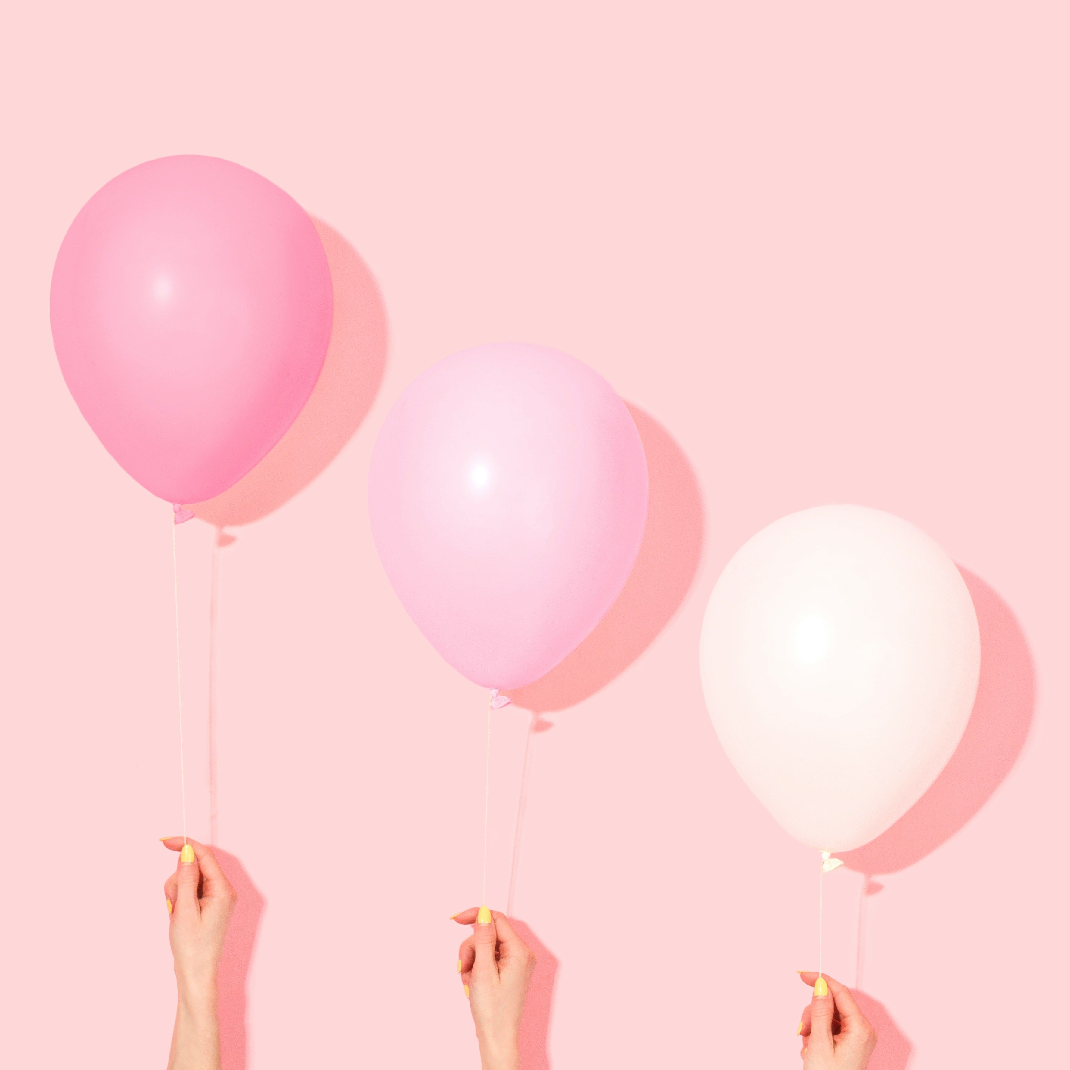 A trio of pastel balloons float gracefully