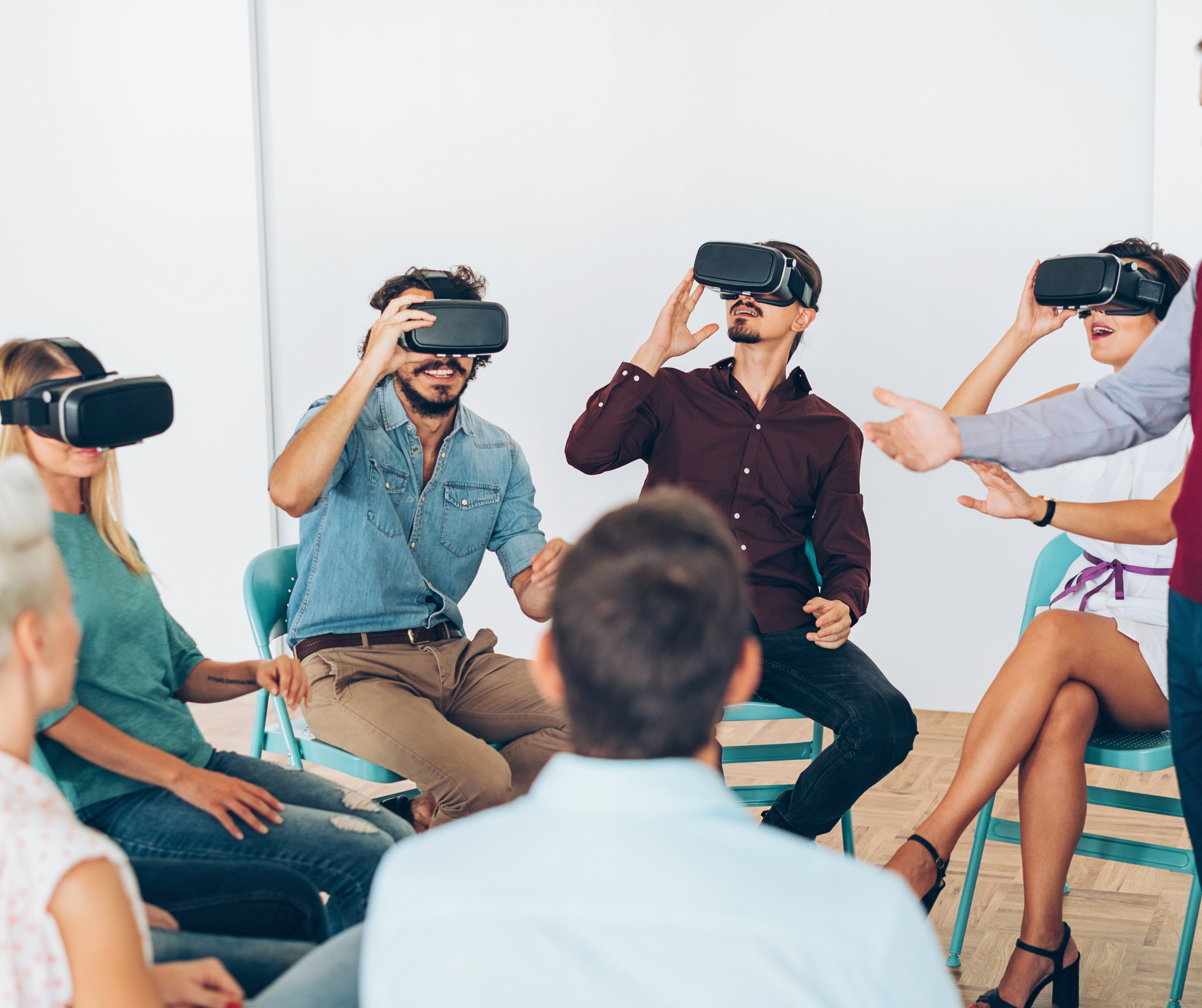 Group of people using VR headsets in a brightly lit room, experiencing immersive VR together.