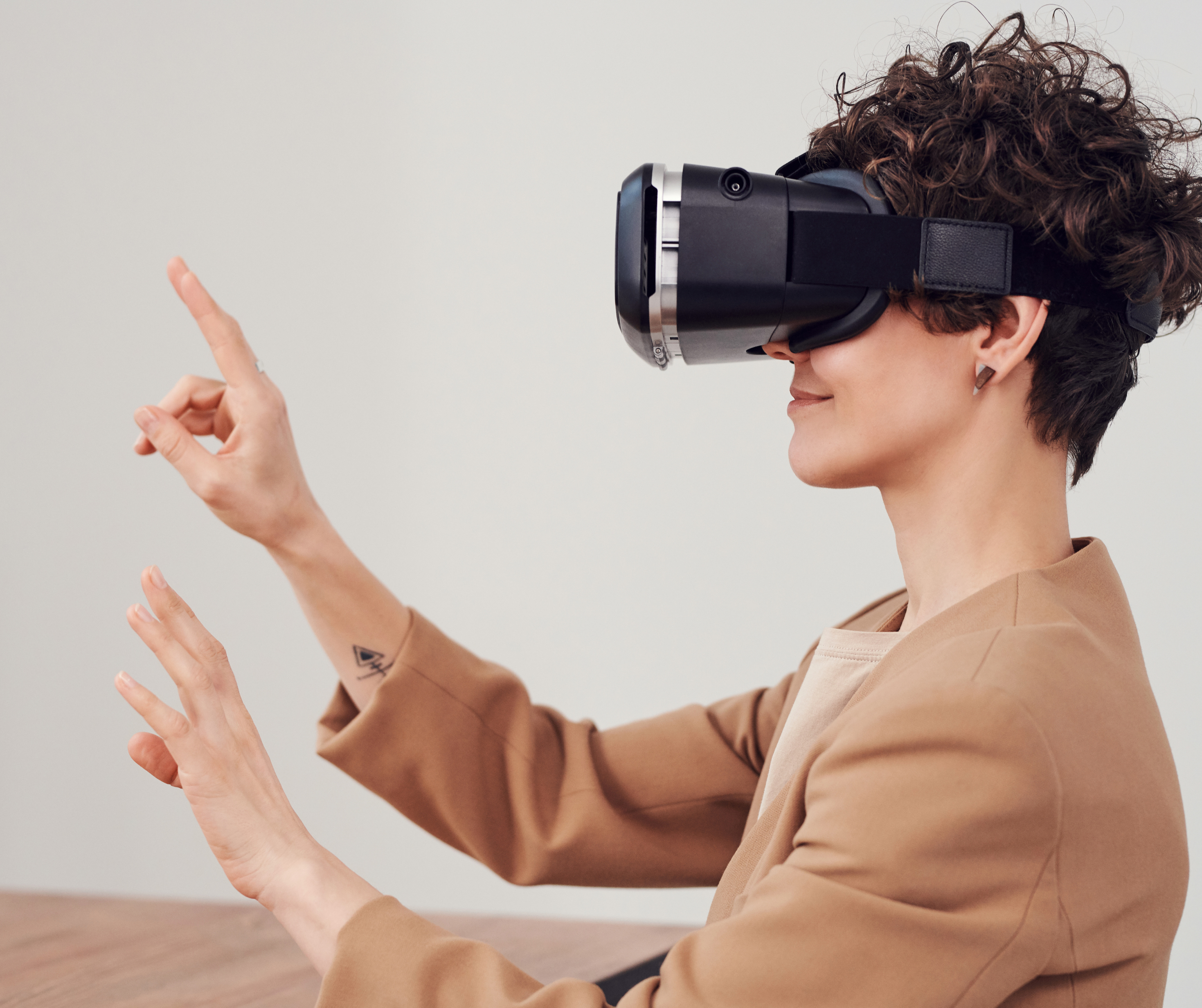 A person wearing a VR headset and gesturing with their hands, experiencing virtual reality.