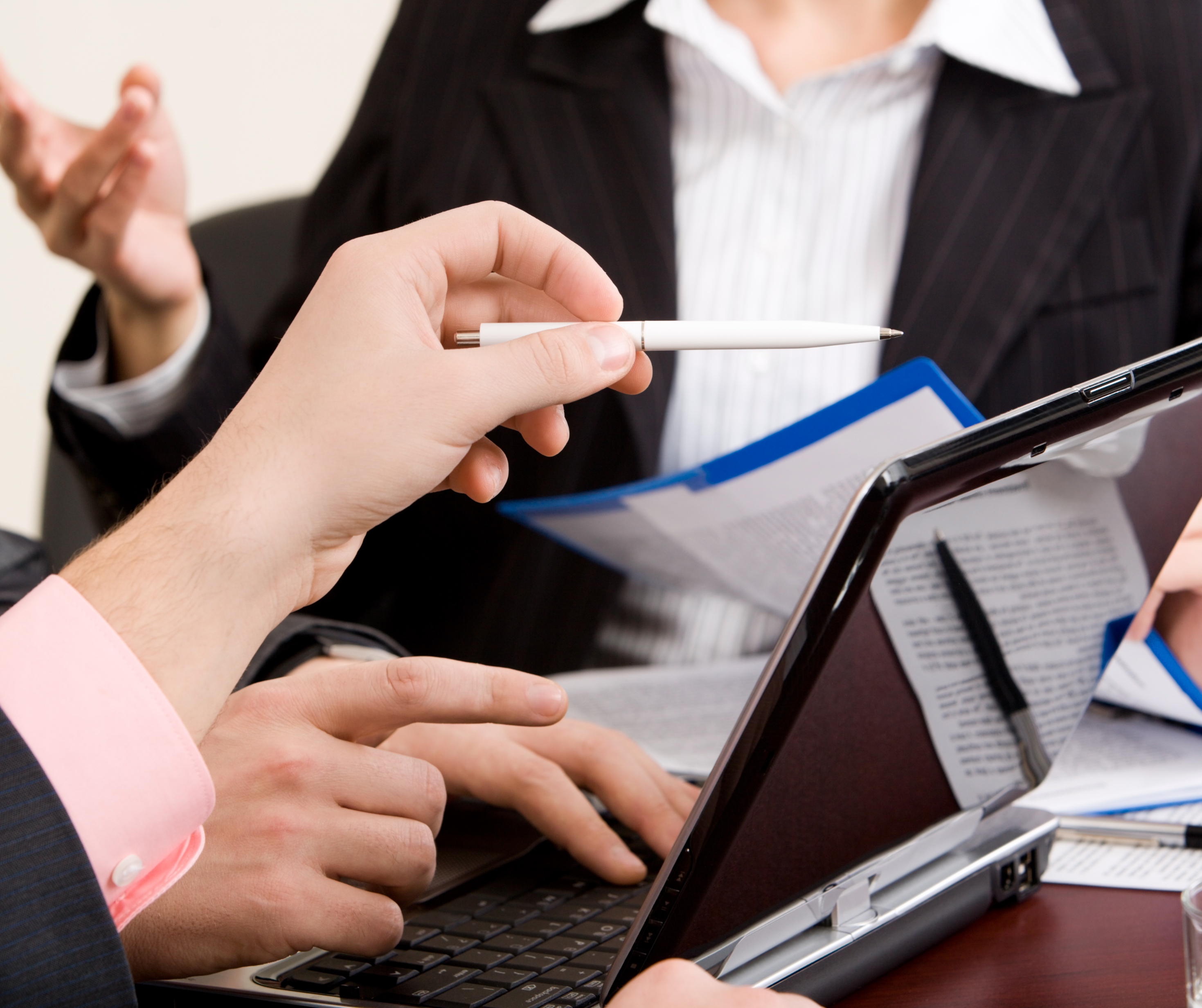 Business professionals analyzing data on a laptop to set clear objectives for a pop-up store.