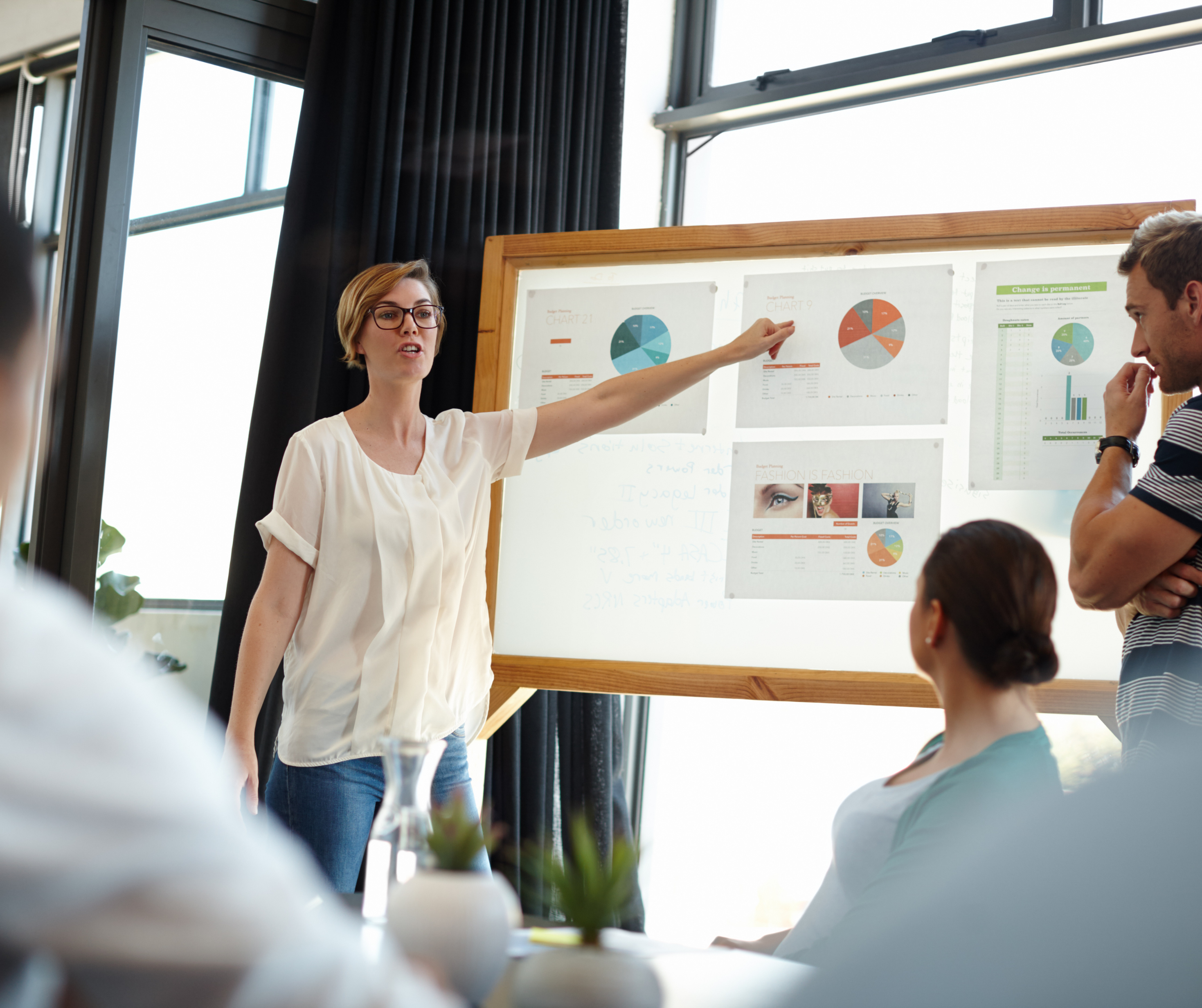  Professional analyzing data on multiple screens, surrounded by charts, graphs, and world maps representing data analytics.