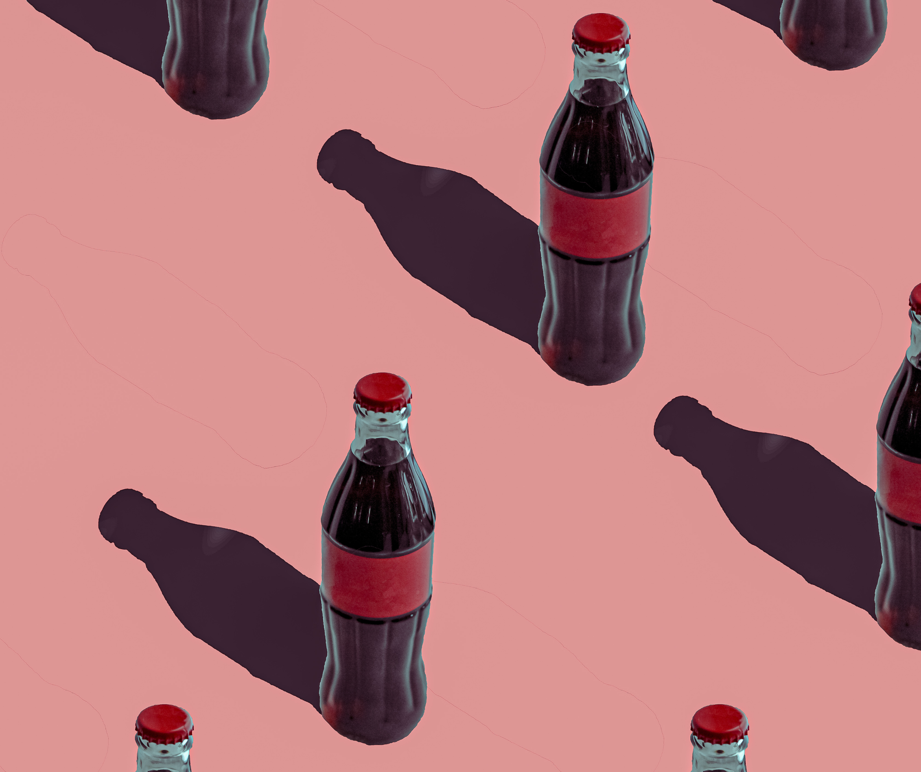 Coca-Cola bottles on a pink background.