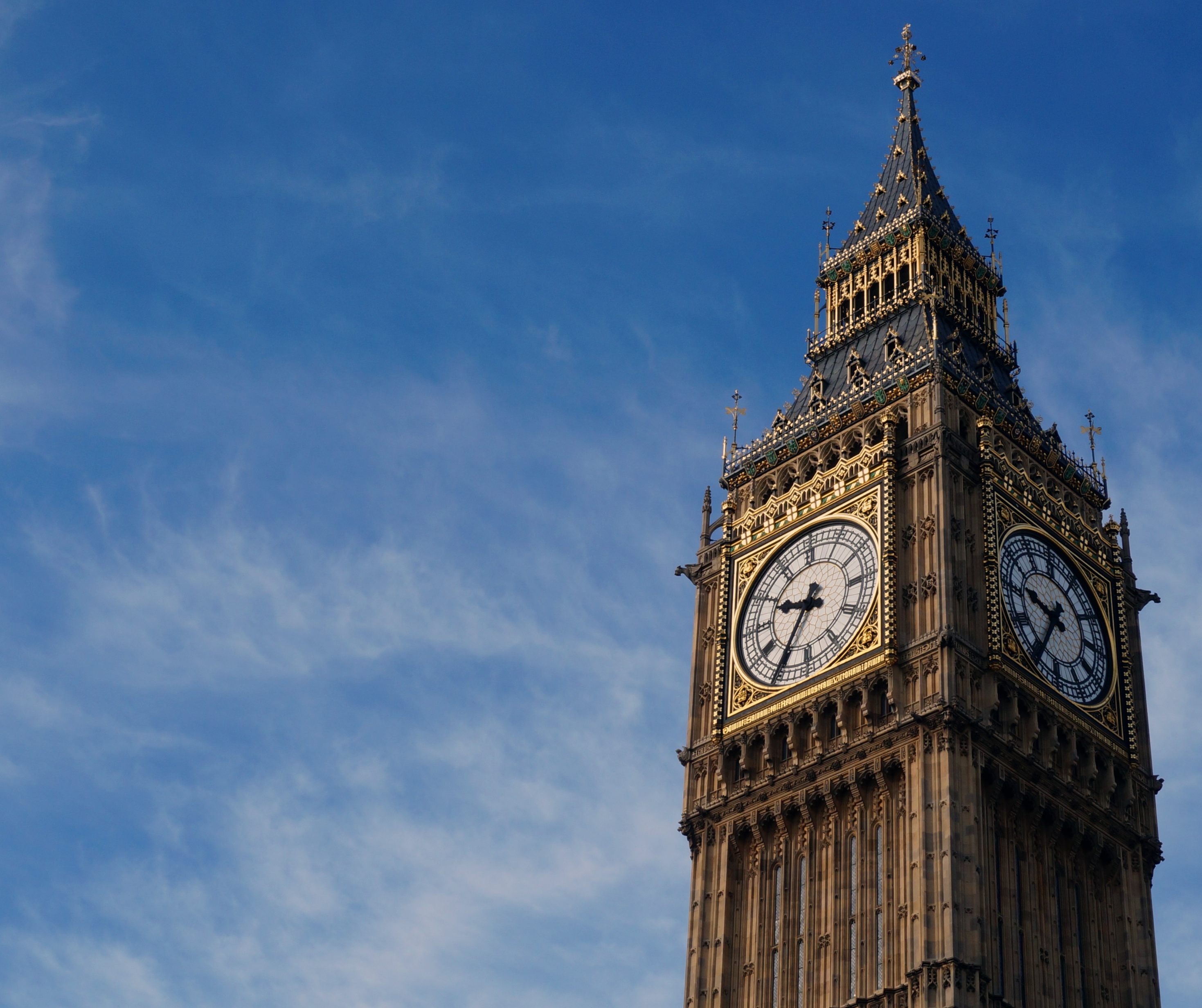 Close-up view of the Big Ben clock tower in London with a clear blue sky in the background.