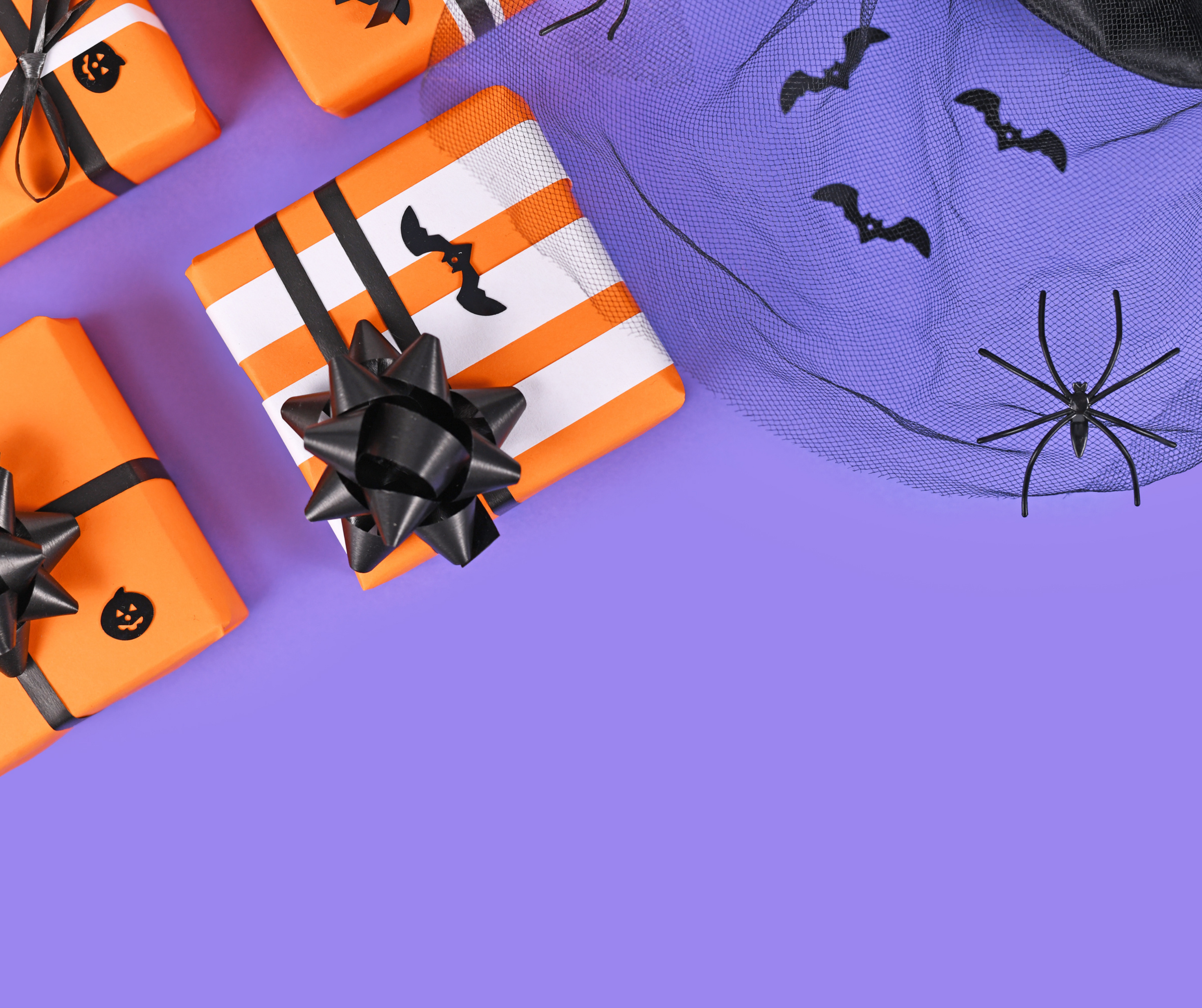 Various Halloween-themed gifts and treats, including decorated candy apples, spooky candles, and festive packaging, ideal for a Halloween celebration in New York.