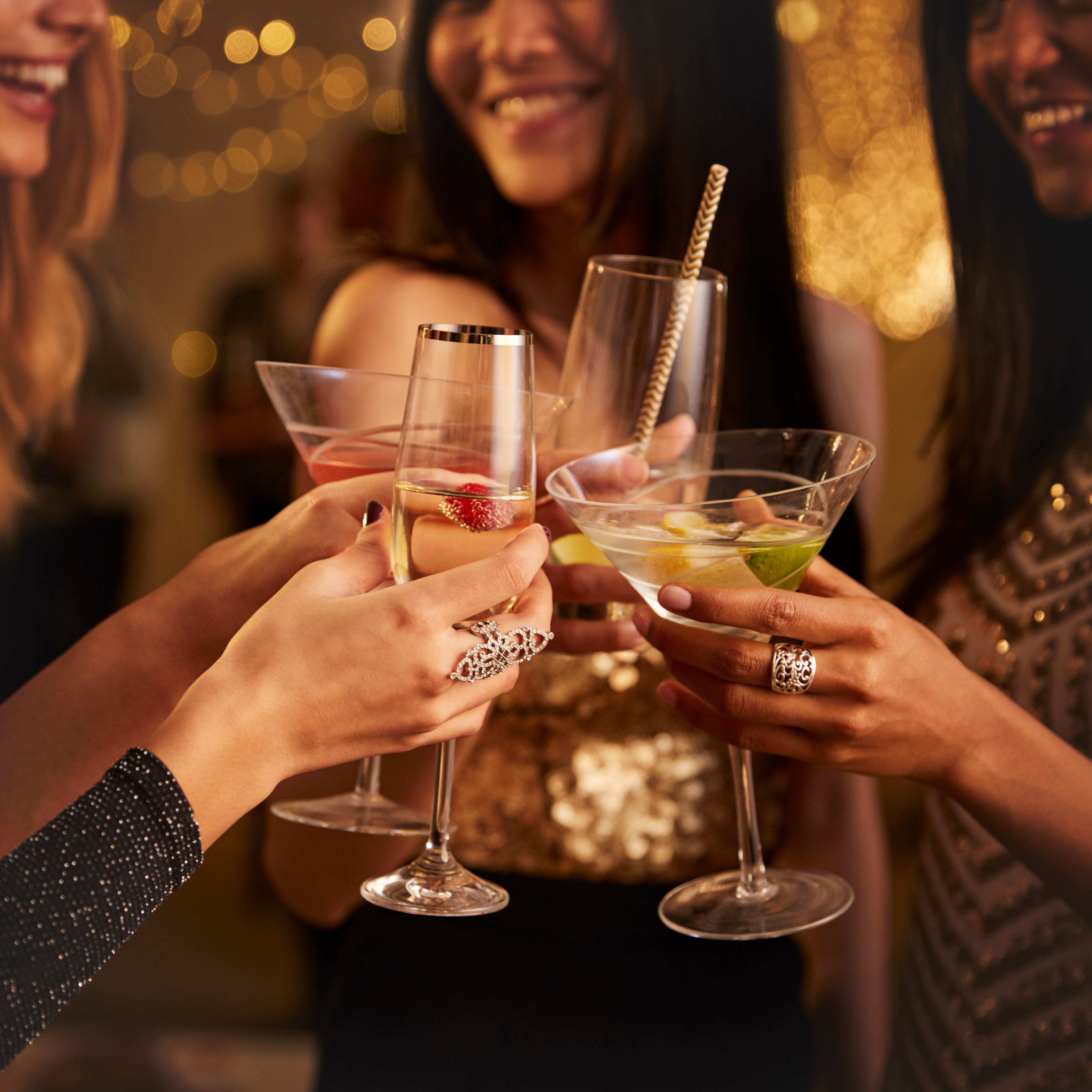  A group of friends toasting with various cocktails in an elegant party setting, highlighting their joyful expressions and stylish attire