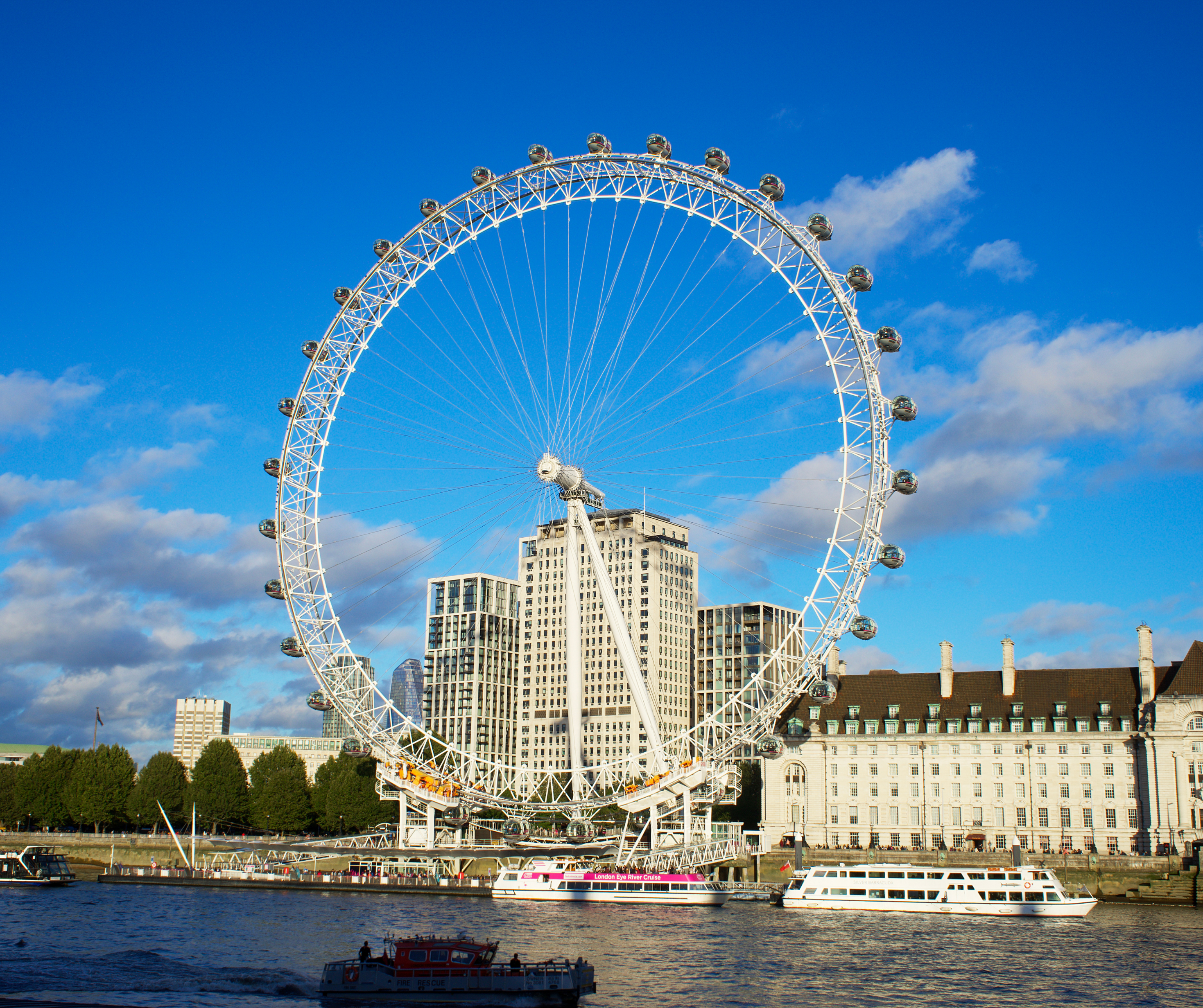 The iconic London Eye Ferris wheel against a clear blue sky.