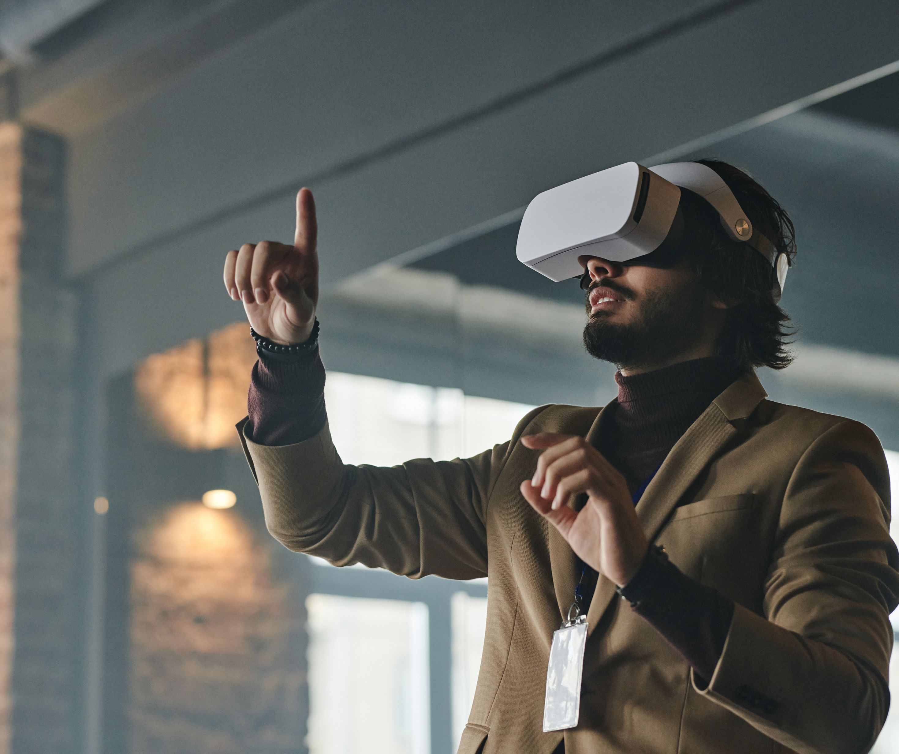 A man wearing a virtual reality headset, gesturing with his hands, experiencing immersive virtual reality content.