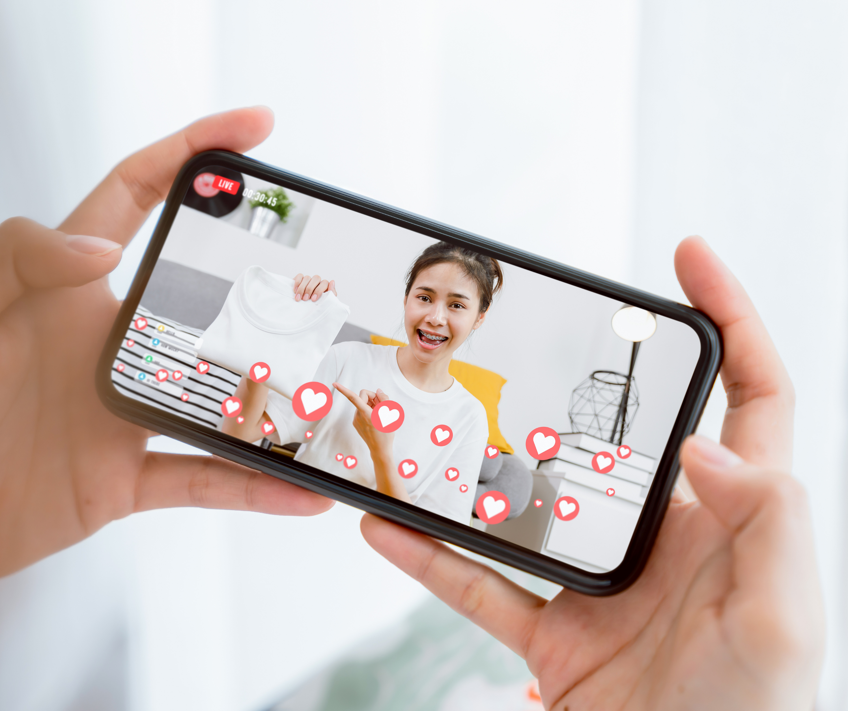 Person holding a phone streaming a live session with interactive likes, representing Instagram Stories and Facebook Live