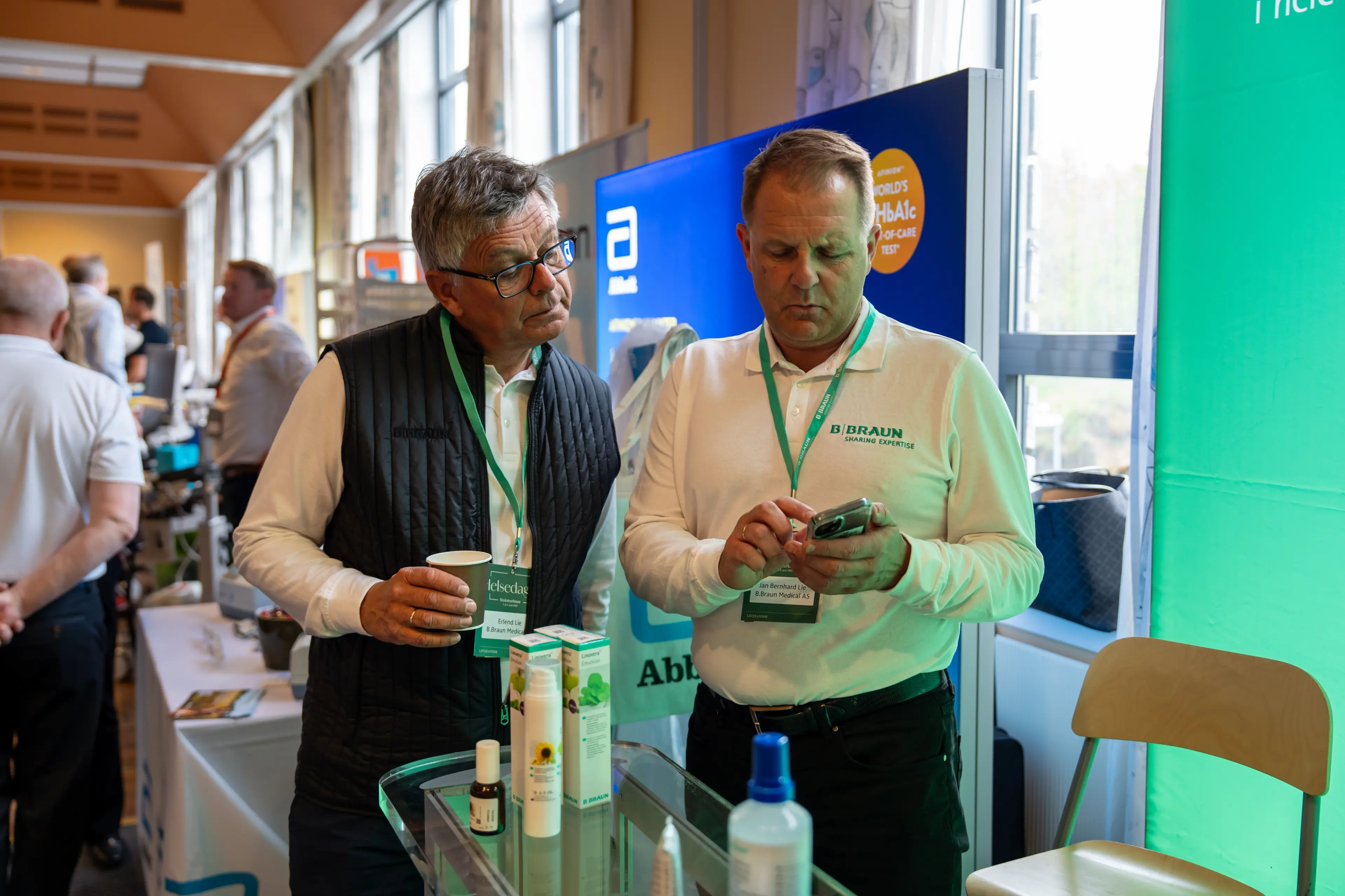 En representant fra B. Braun viser en annen representant noe på telefonen sin