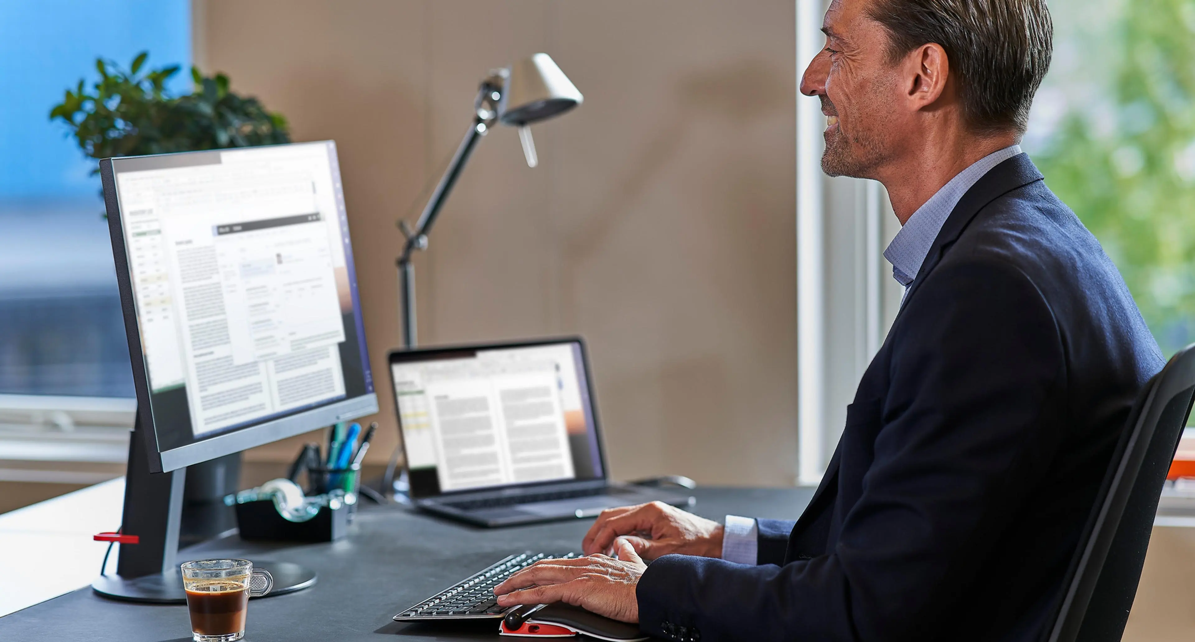 Mann som sitter foran en pc på et kontor