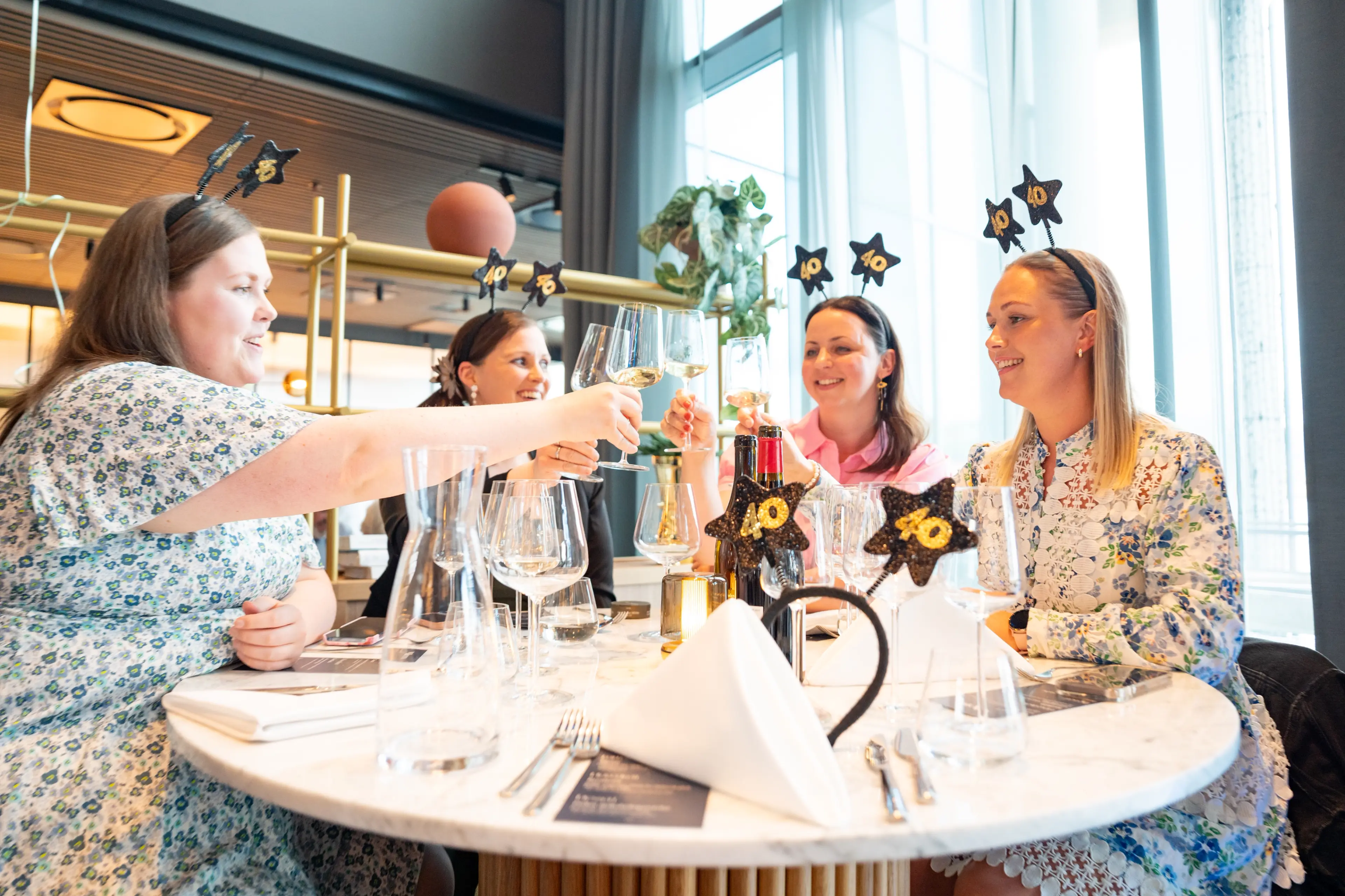 Fire deltakere skåler rundt et pyntet bord med 40-årsjubileumstema under jubileumsmiddagen på Quality Hotel Richard With.