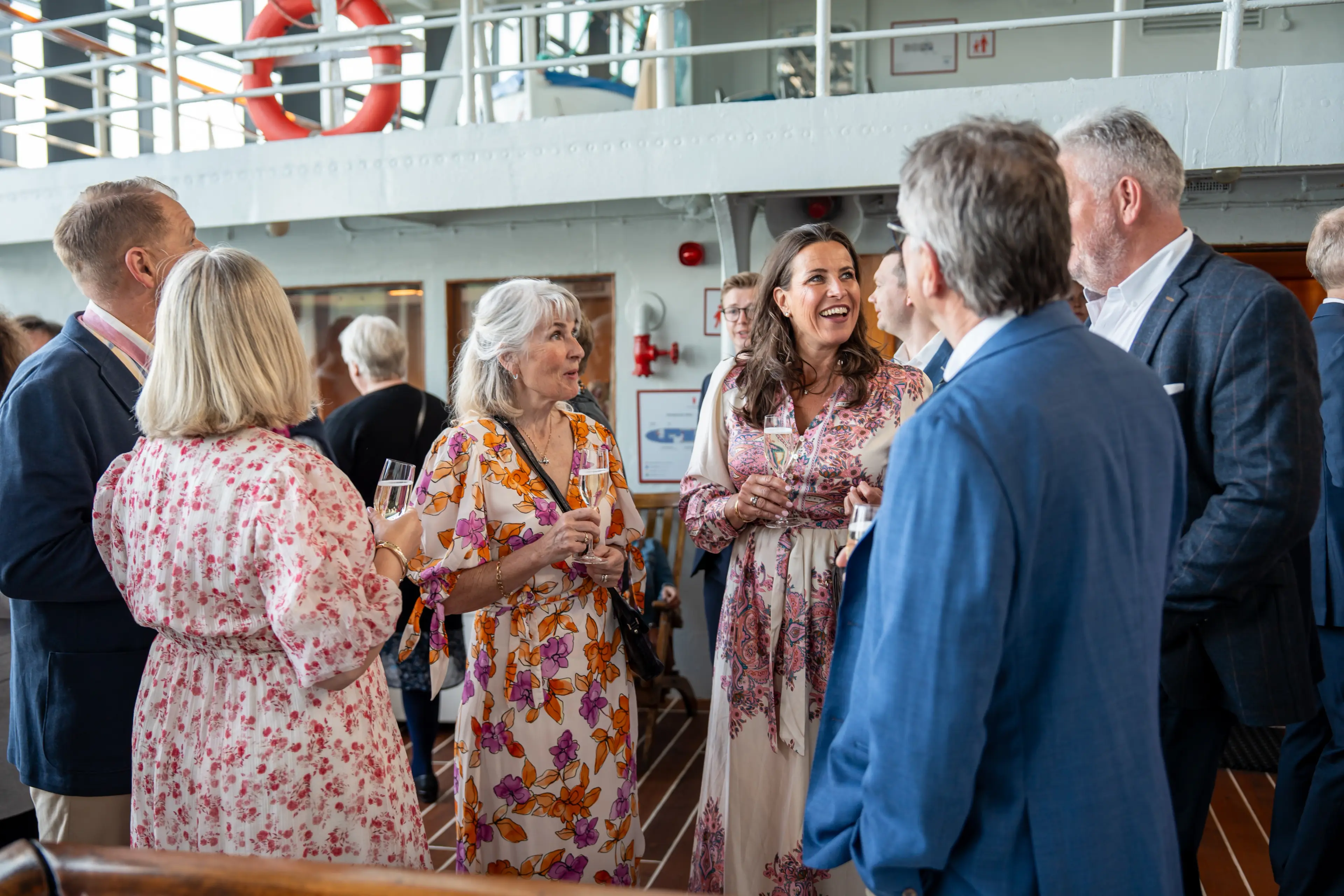 Feststemte deltakere i samtale med aperitiffglass under mottakelsen på Hurtigrutemuseet under Helsedagene 2025.