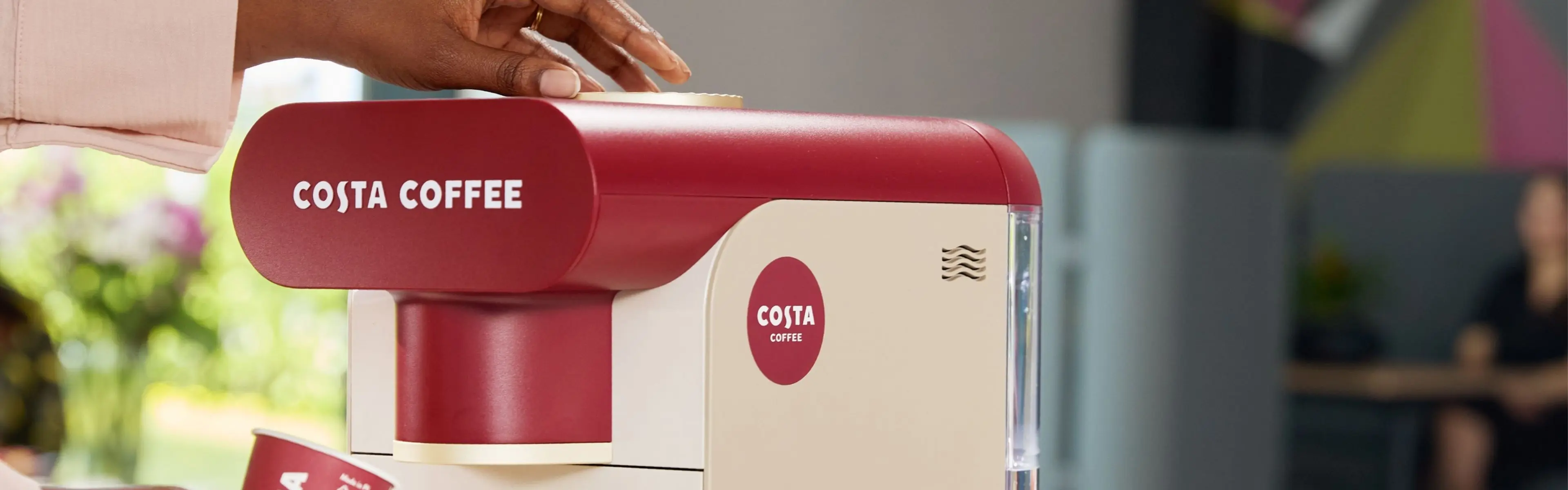 Person tar kaffe fra Costa Podio X1 kaffemaskin