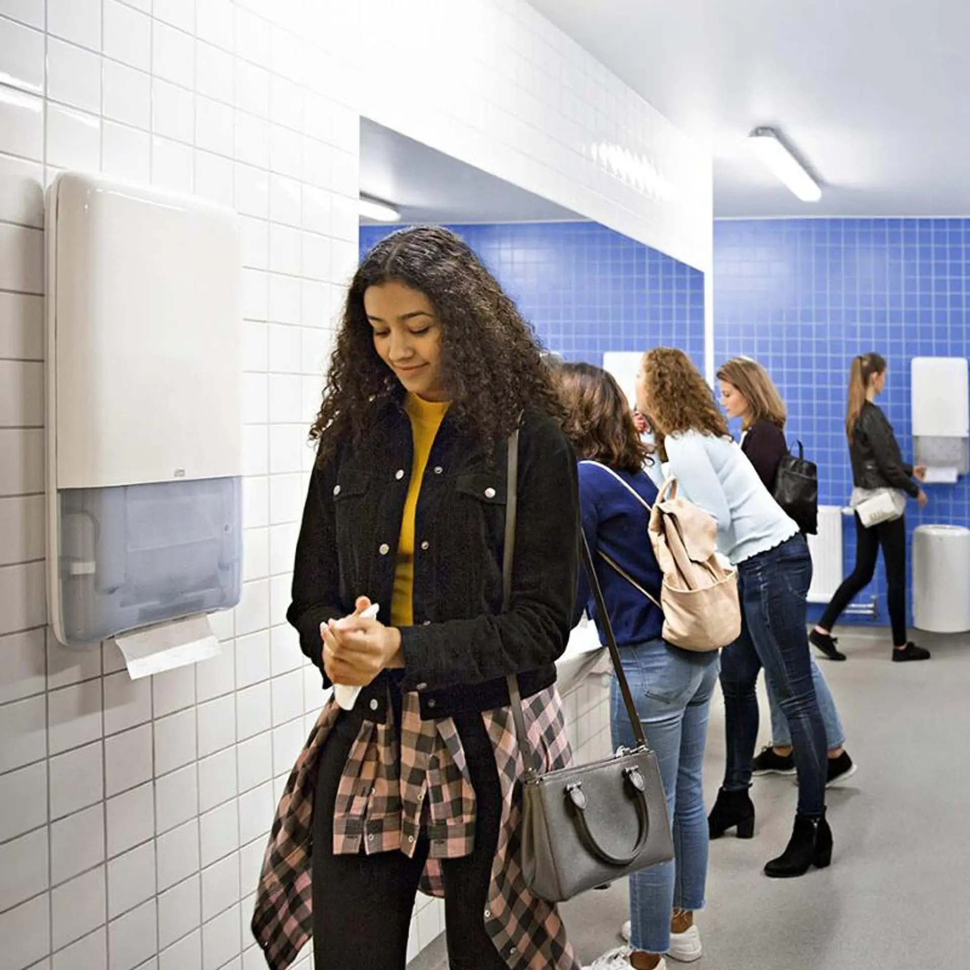 Dame som tørker hendene med papir fra Tork peakserve