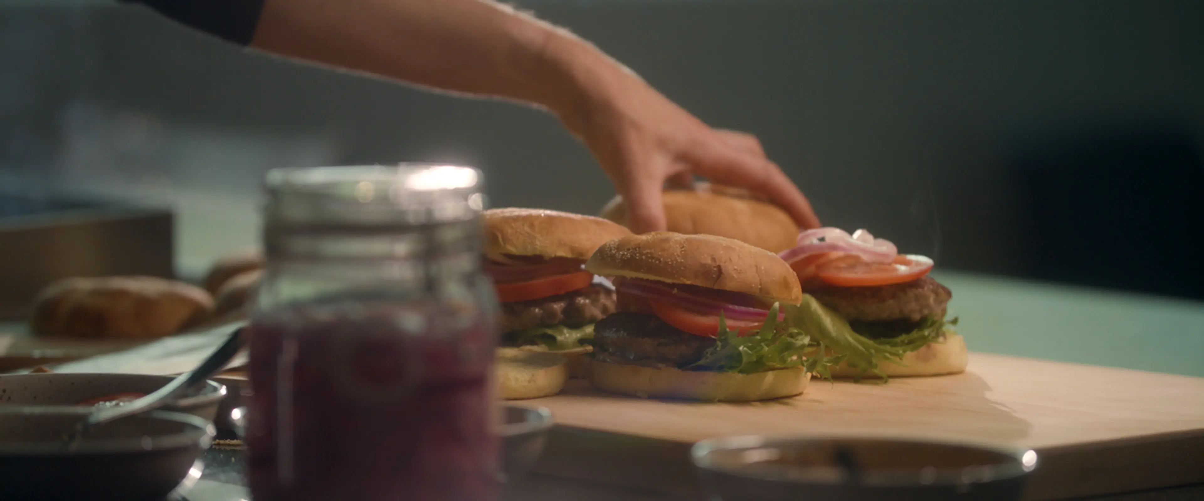 Kokk som tilbereder hamburgere