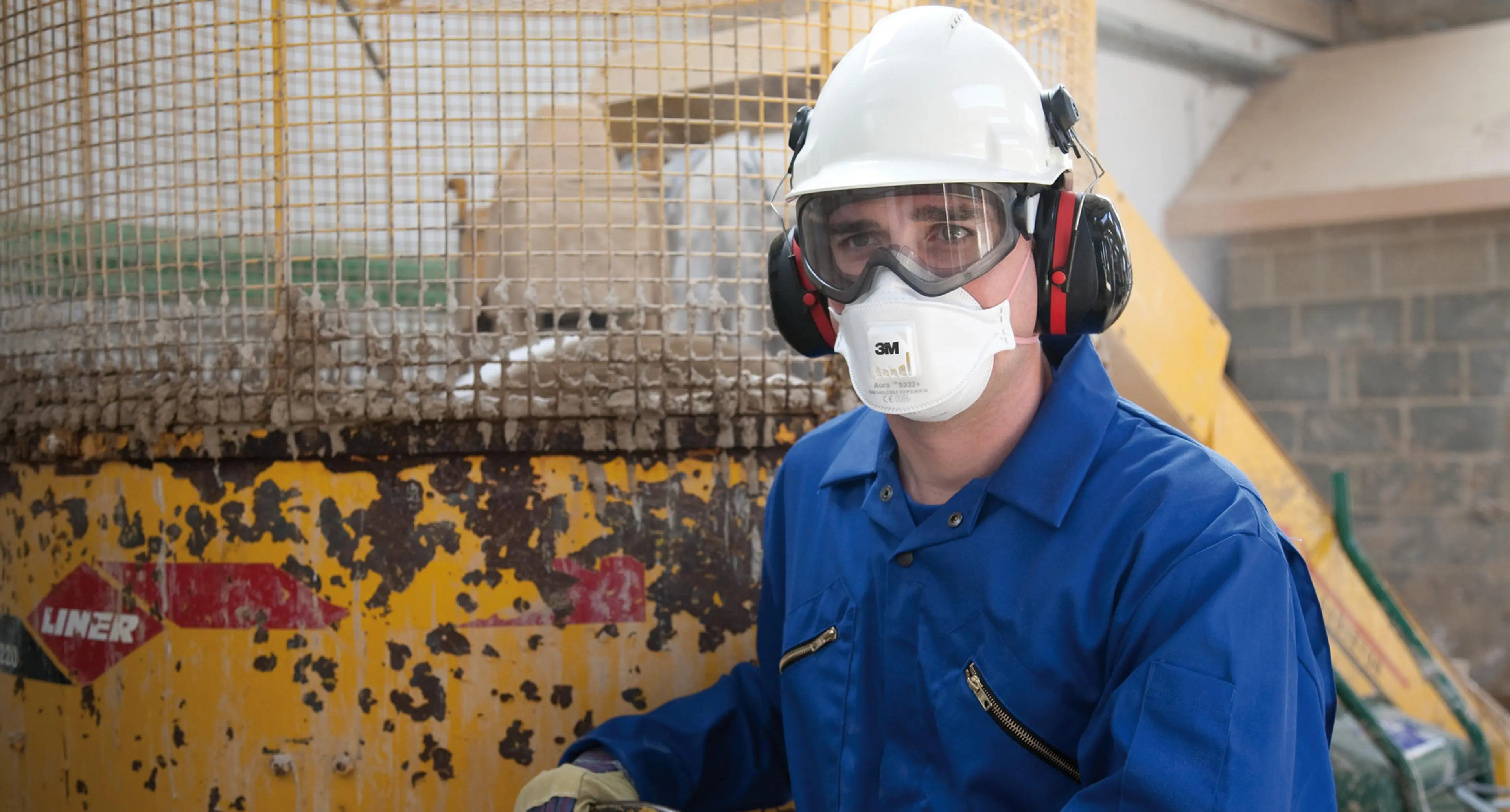 Industriarbeider med hjelm og maske