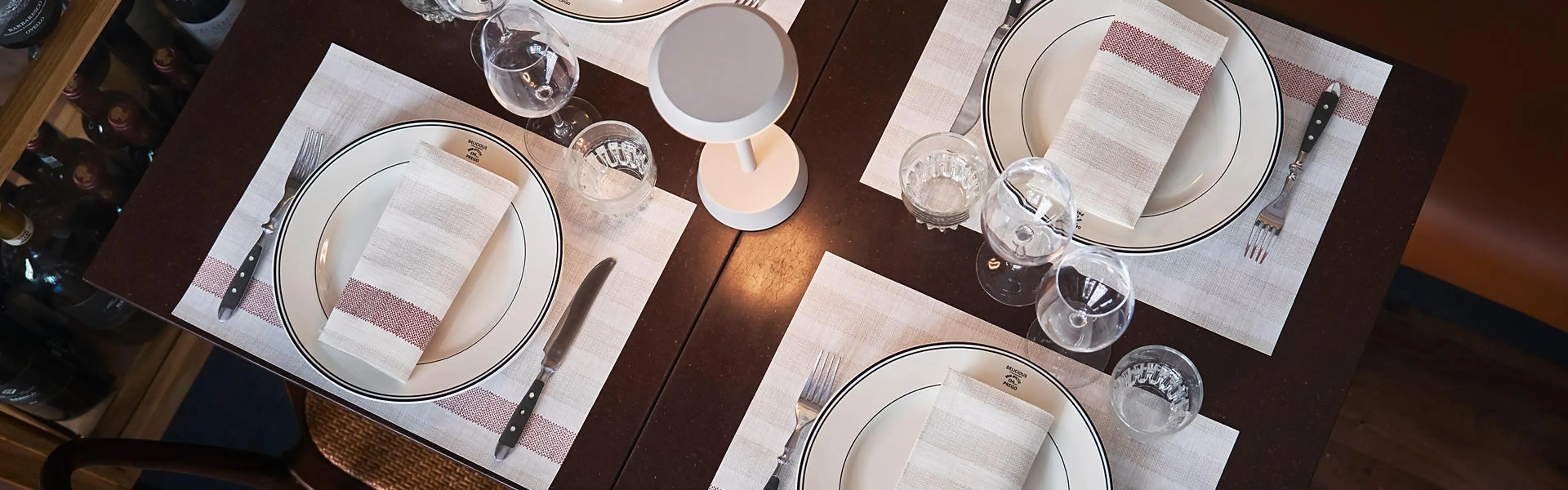 Bord dekket med servietter, bestikk, glass og tallerkner