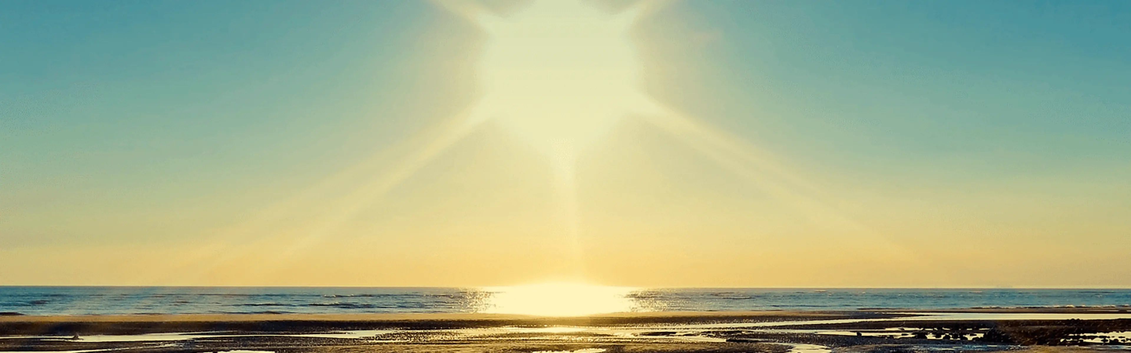 Sola som skinner over havet