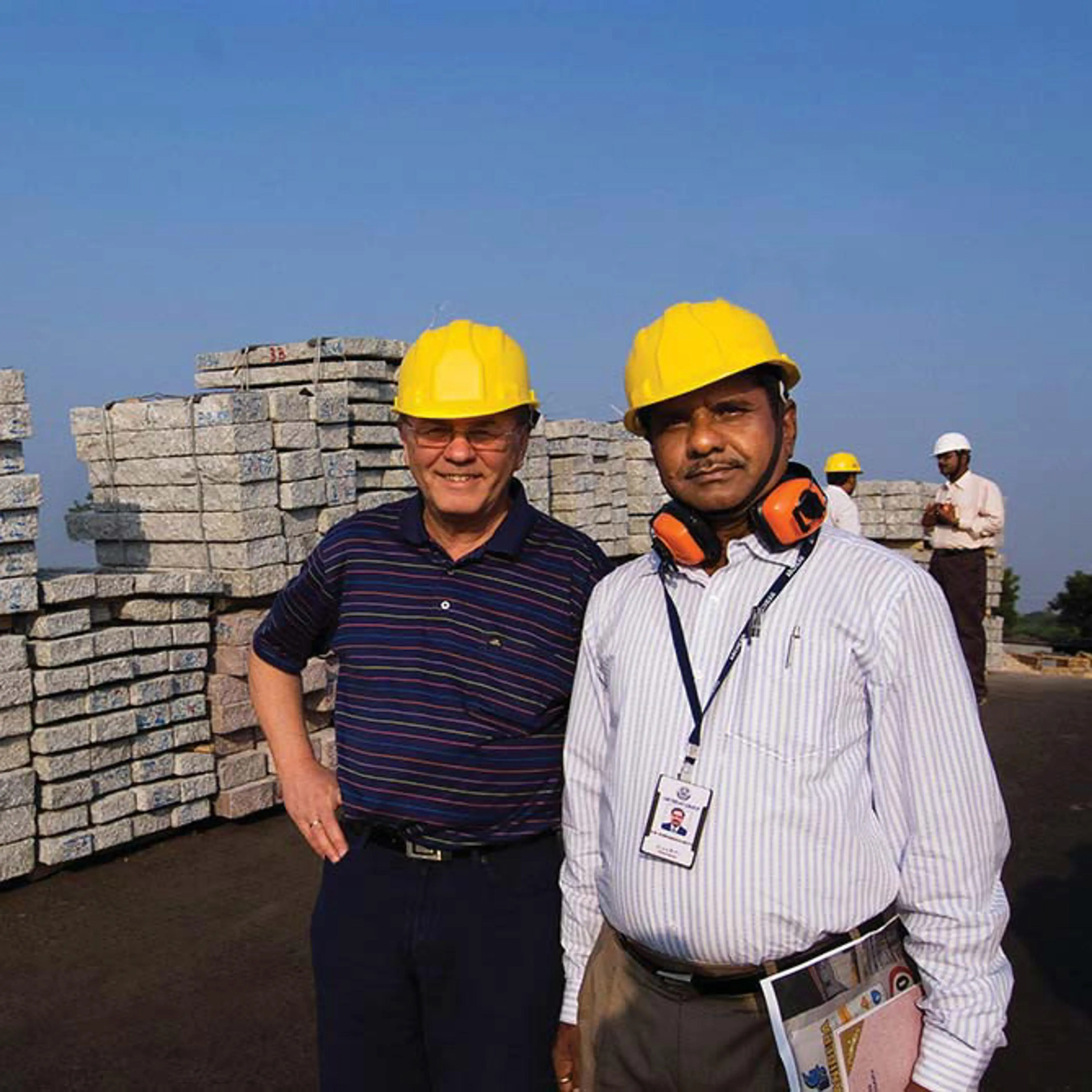 To menn står forran en stabel med stein