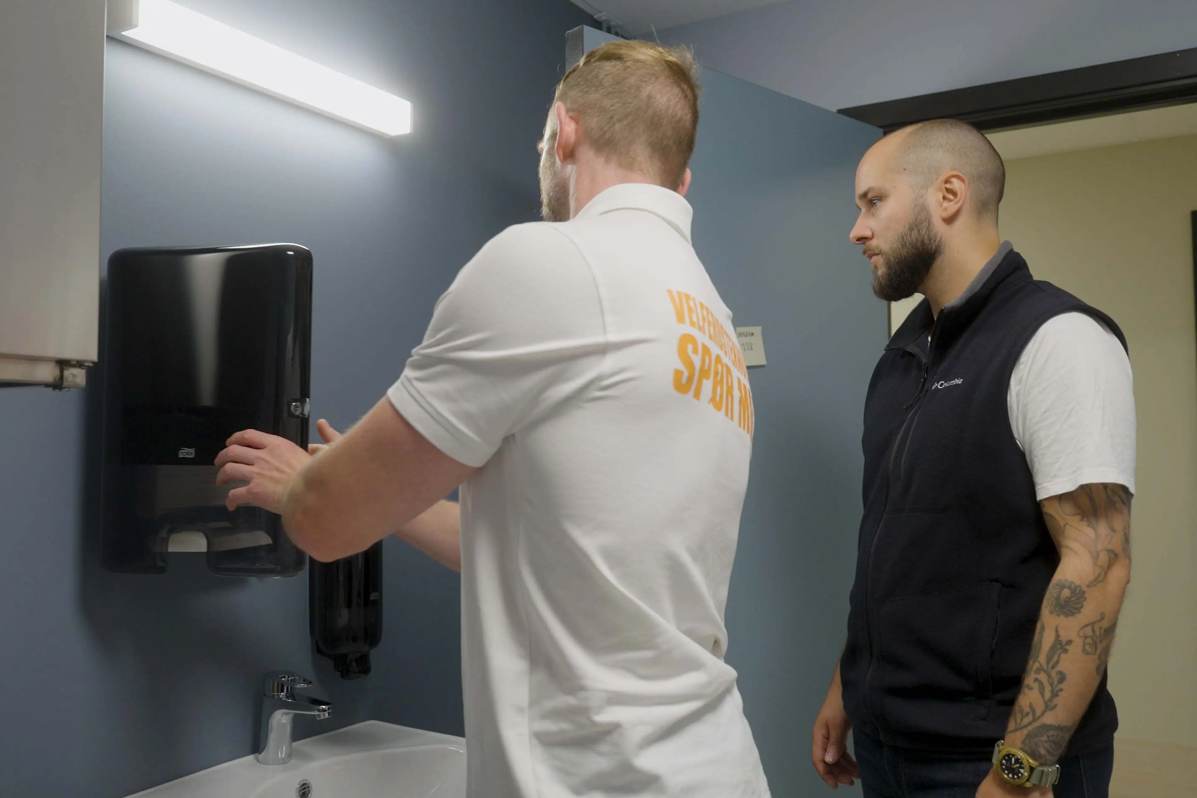 Salgskonsulent demonstrerer papirdispenser for kunde