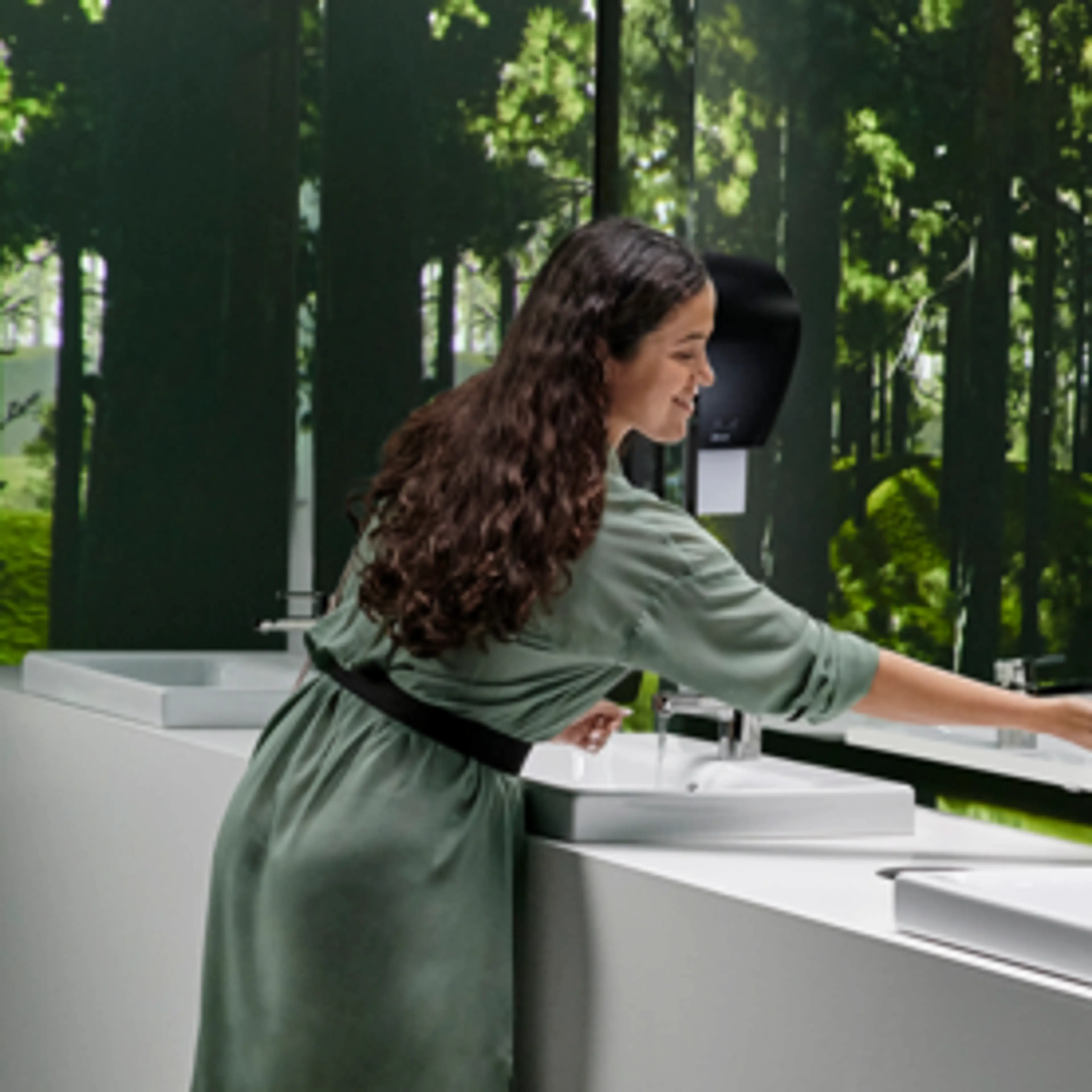 Kvinne som tørker hendene på et toalettrom