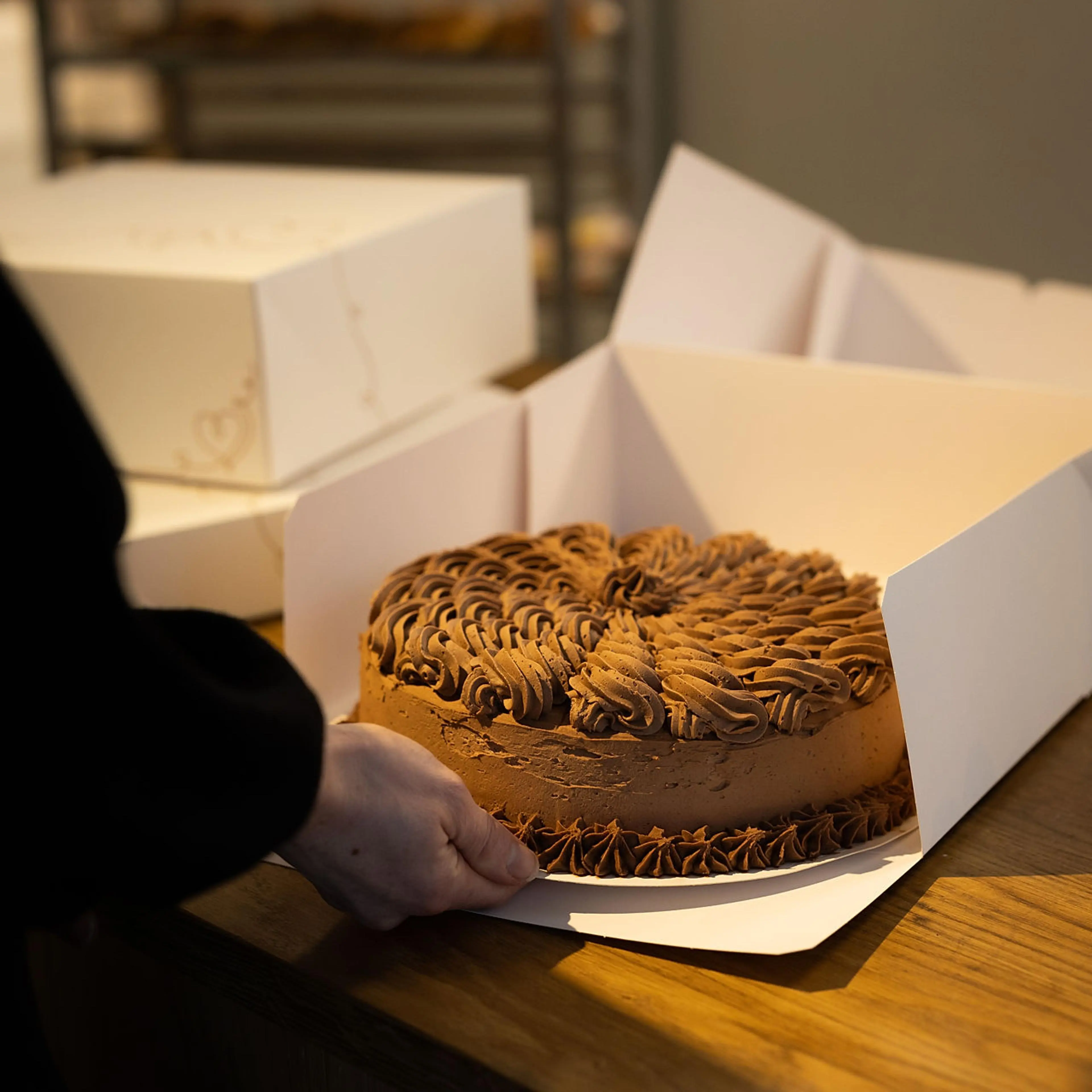 Person putter kake inn i Stund kakeeske