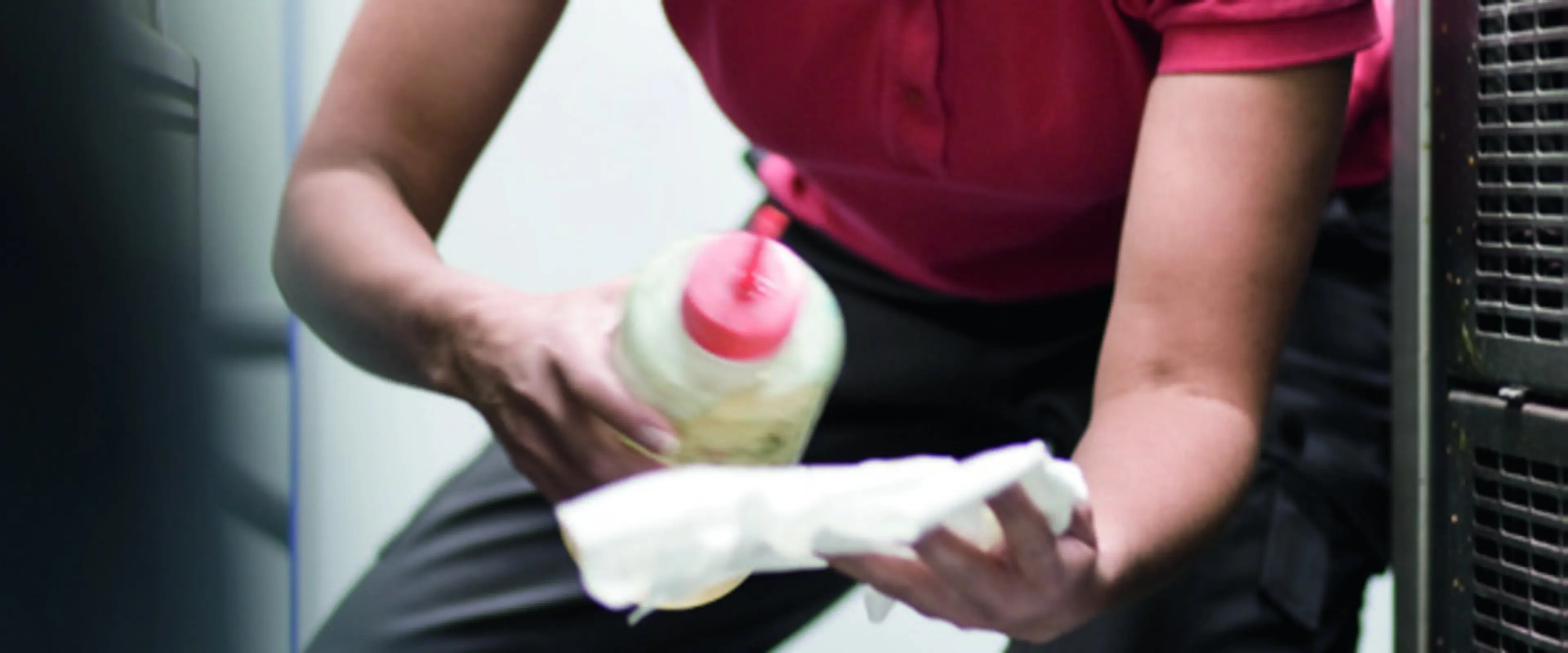 Renholder som tar på kjemikaler i en renholdsklut