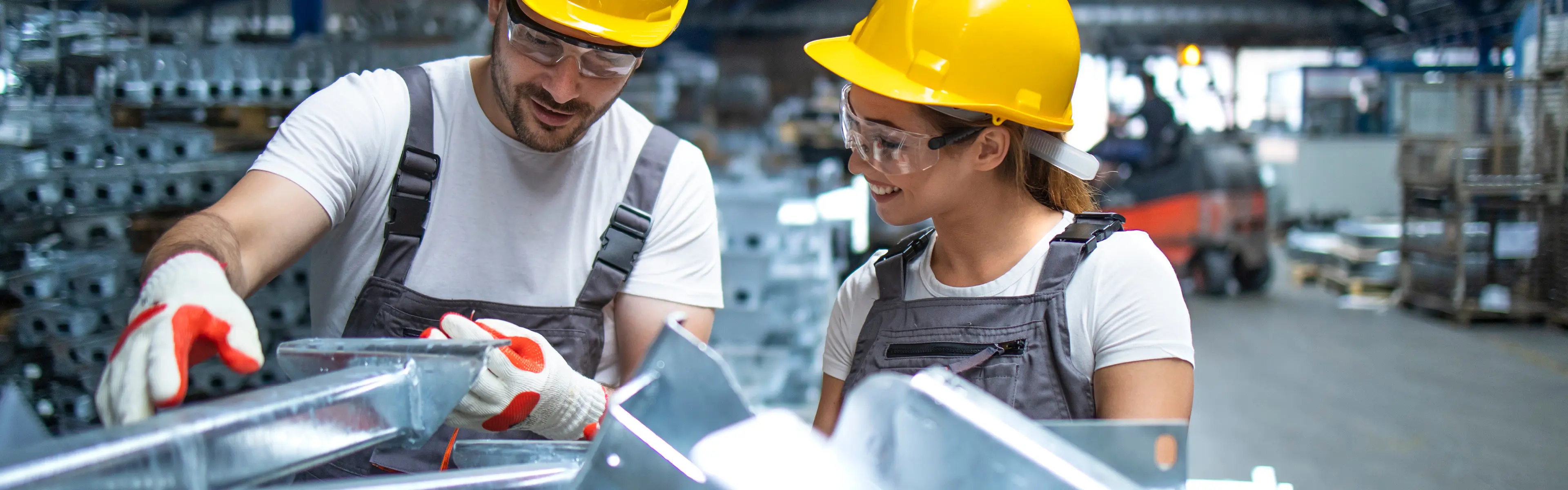 Personer i fabrikk ser på aluminium