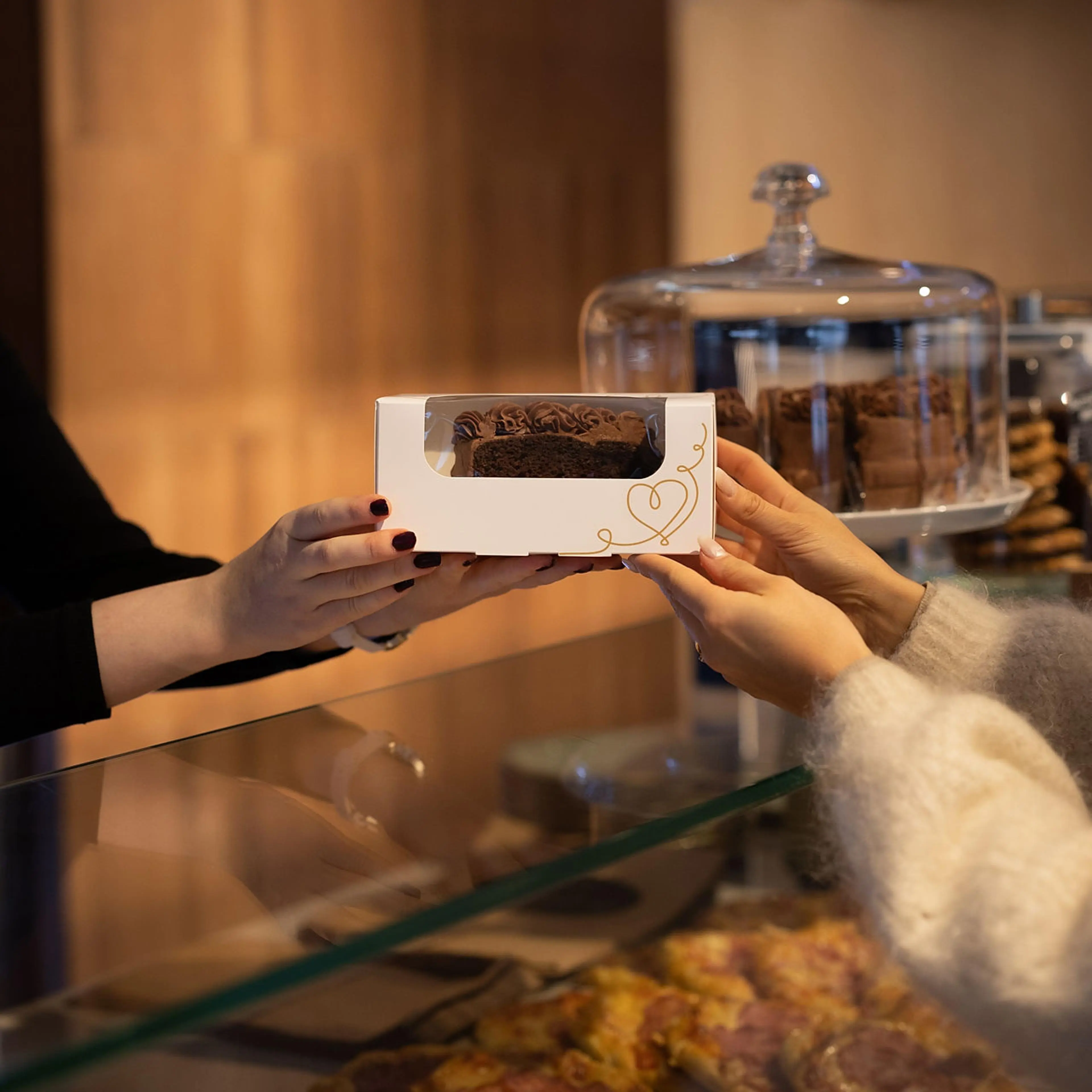 Stund kakeeske rekkes med kake over disk i bakeri