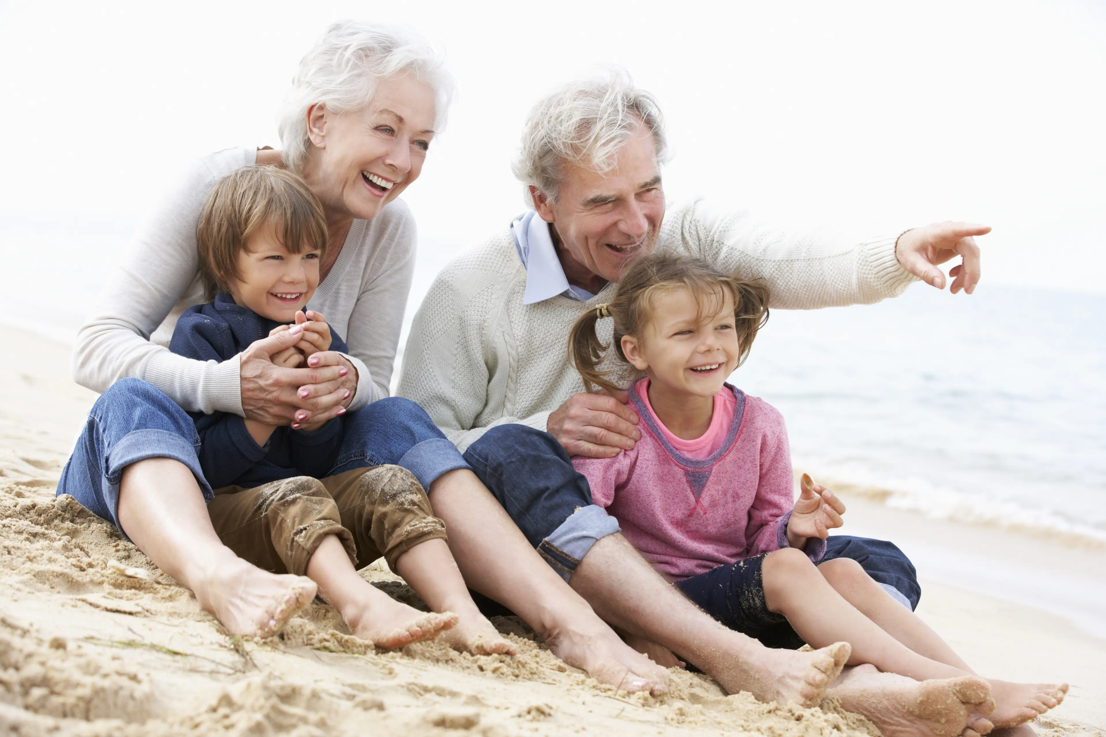 Eldre ektepar sammen med to barn på en strand