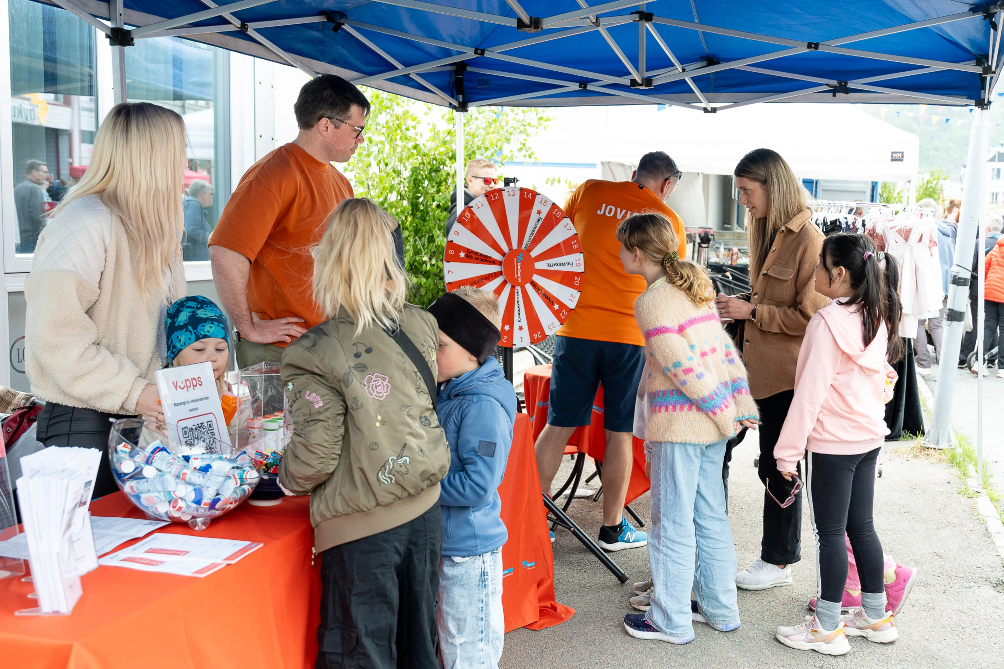 Barn og vokse i kø under Folkefesten i forbindelse med Arctic Run 2024 hvor Norengros Helseservice og NB Engros var generalsponsor