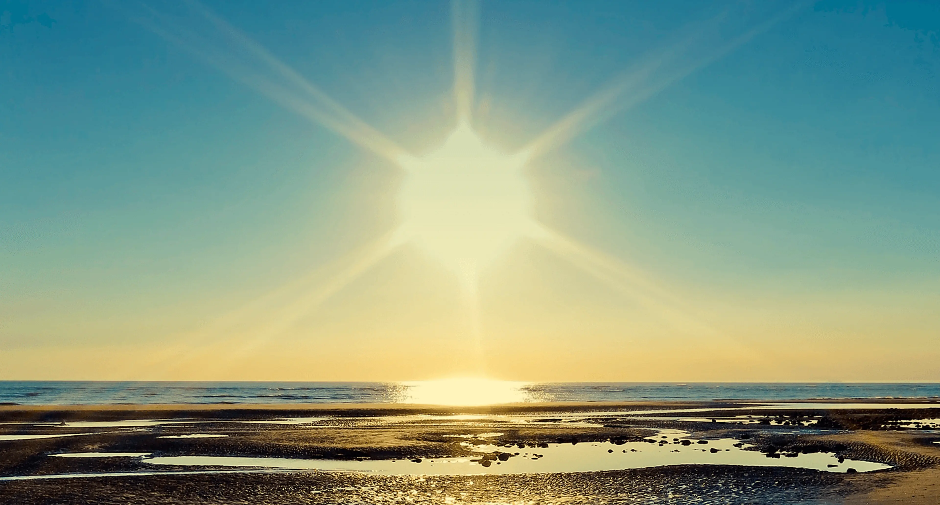 Sola som skinner over havet