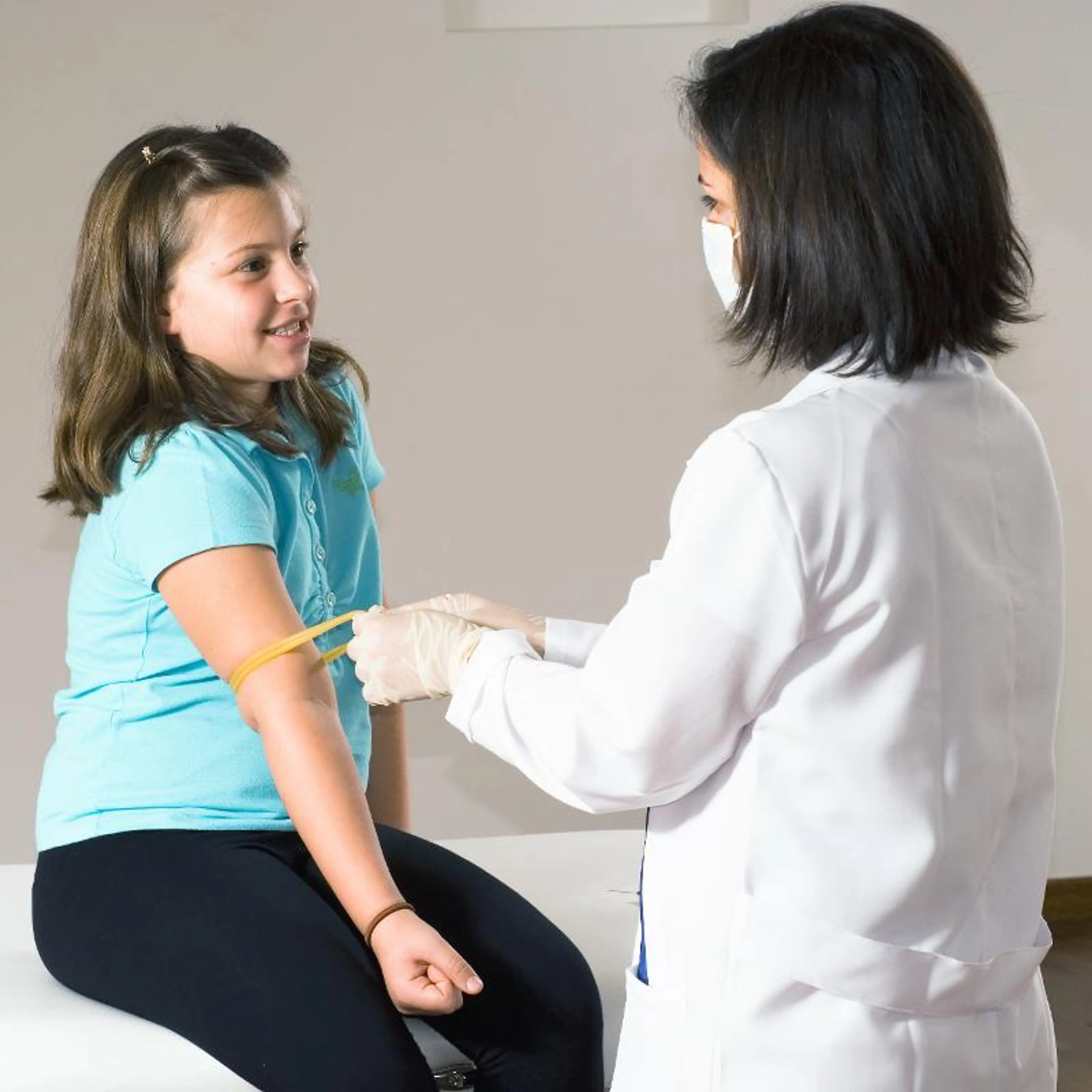 Sykepleier som måler armen til en jente
