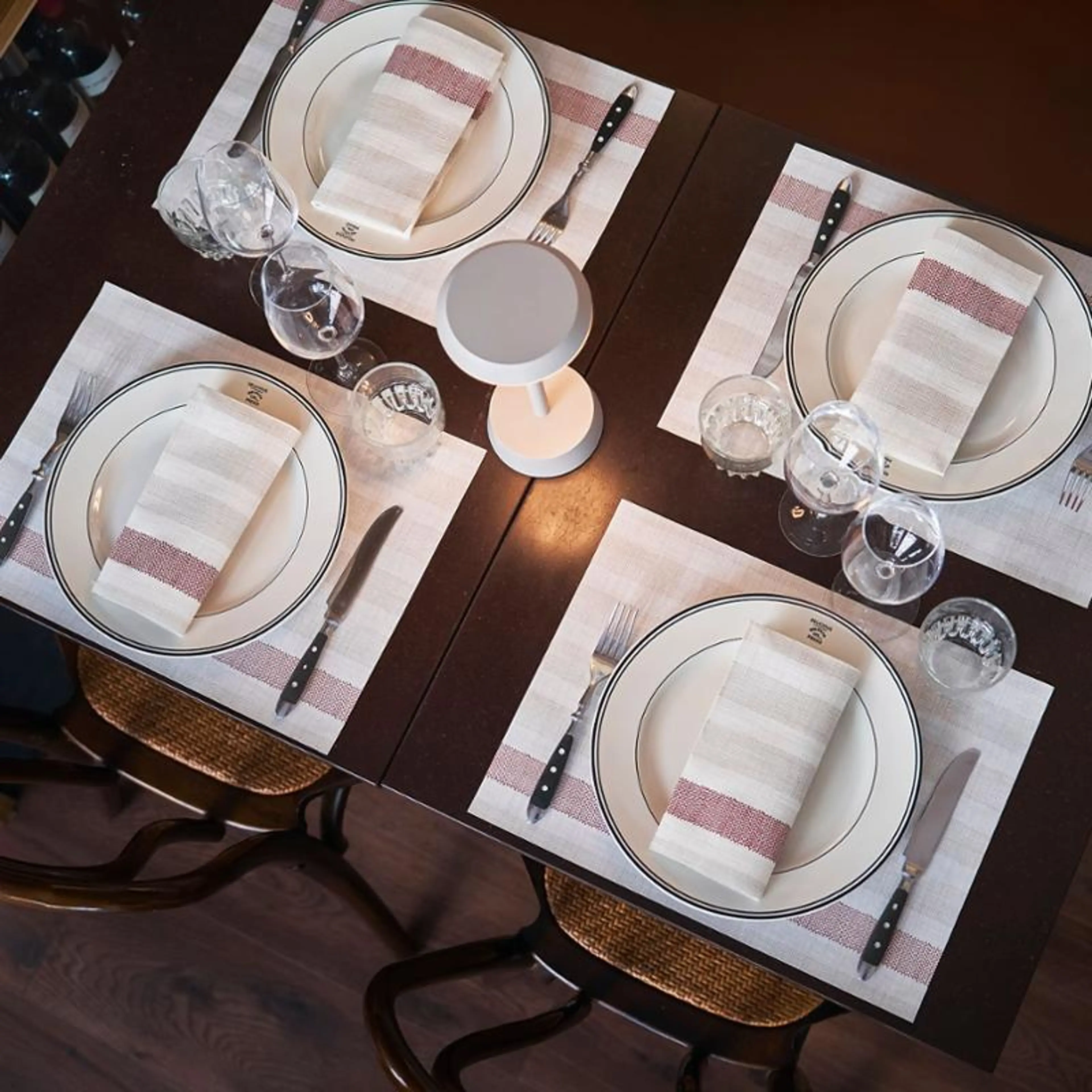 Bord dekket med servietter, bestikk, glass og tallerkner