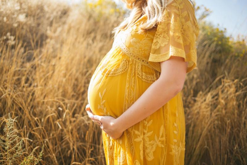 Gravid kvinne med hendene under magen