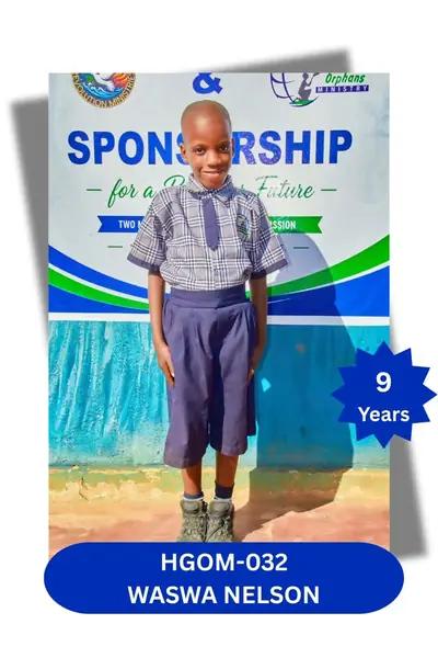 Boy in a plaid shirt and tie with navy shorts, standing before a banner