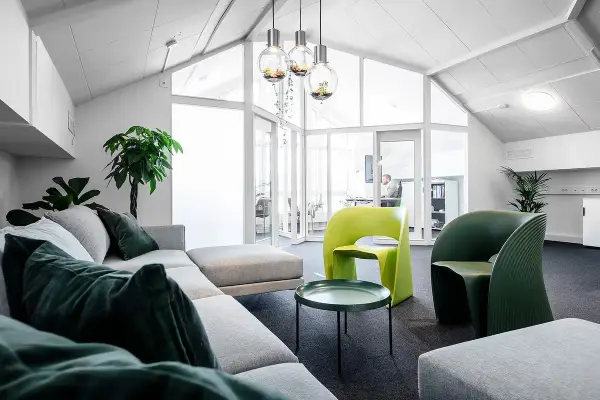 Ljus lounge med gröna fåtöljer i ENRECONs kontor