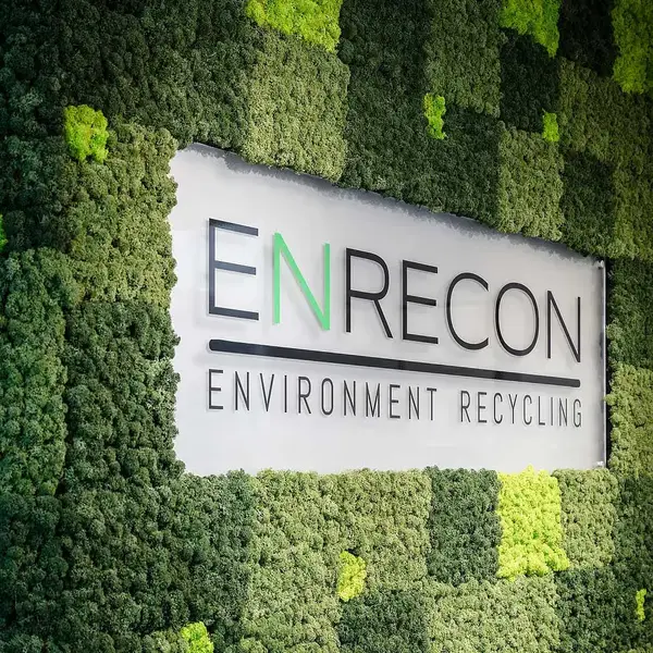 ENRECONs logotyp på en vägg av mossa