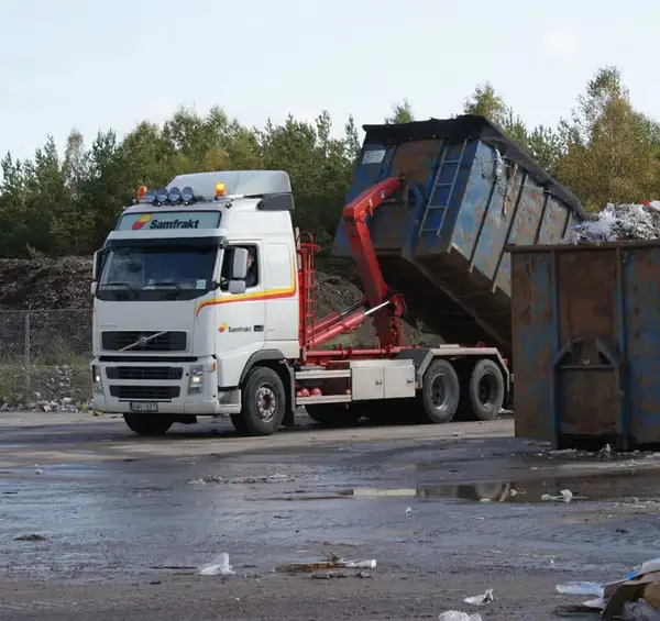 Lastbil tippar en container med avfall