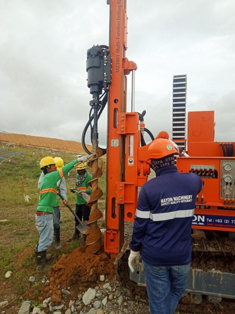 Crew in safety gear guiding a pile for a solar panel mounting structure