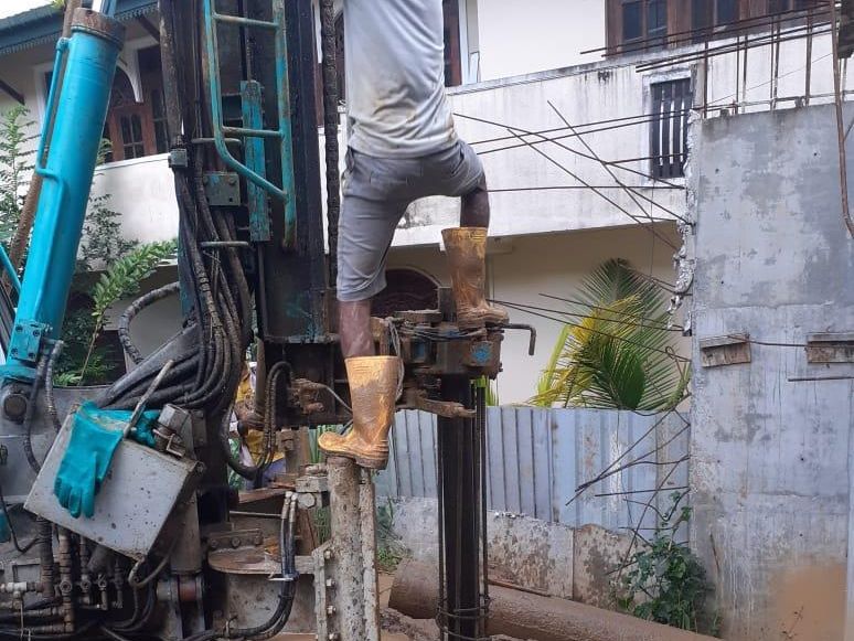 Micro pile rig drilling beside an existing house on a tight residential plot