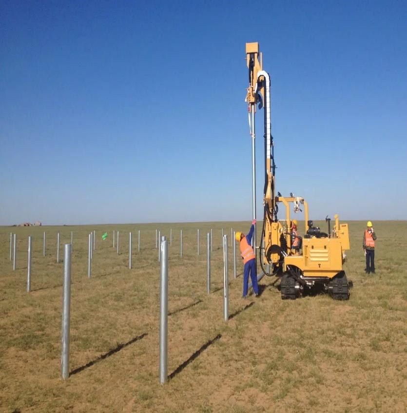 Pile driving machine installing rows of steel posts for a solar farm