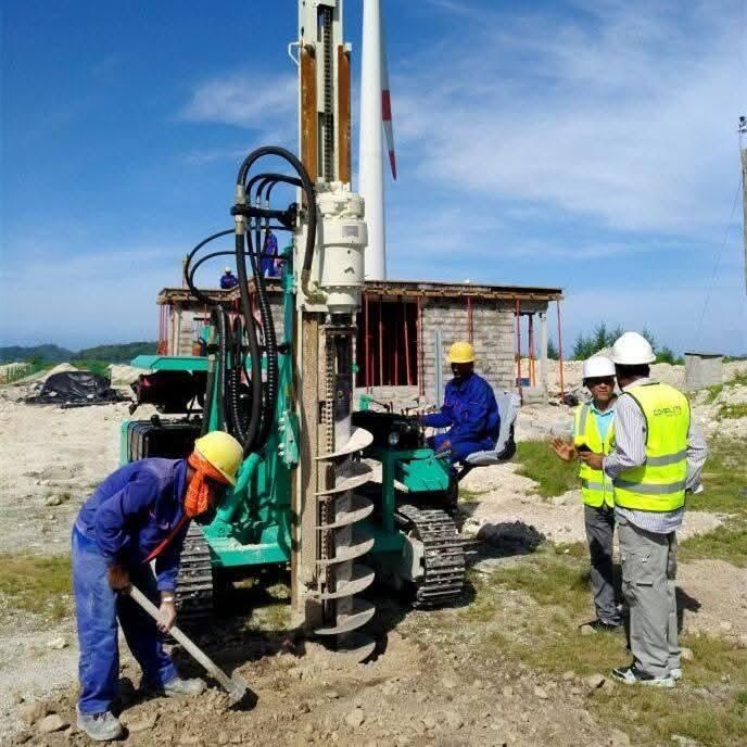 Crew operating a compact tracked drilling rig to install micro piles