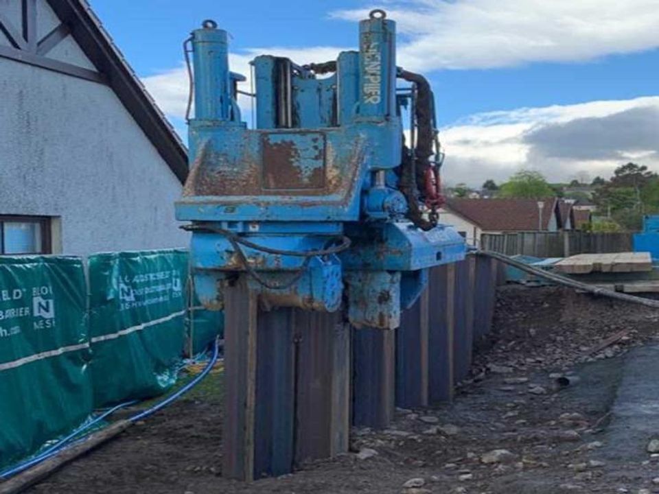 Silent press-in piling machine installing steel sheet piles next to existing buildings