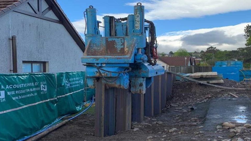 Silent press-in piling machine installing steel sheet piles next to existing buildings